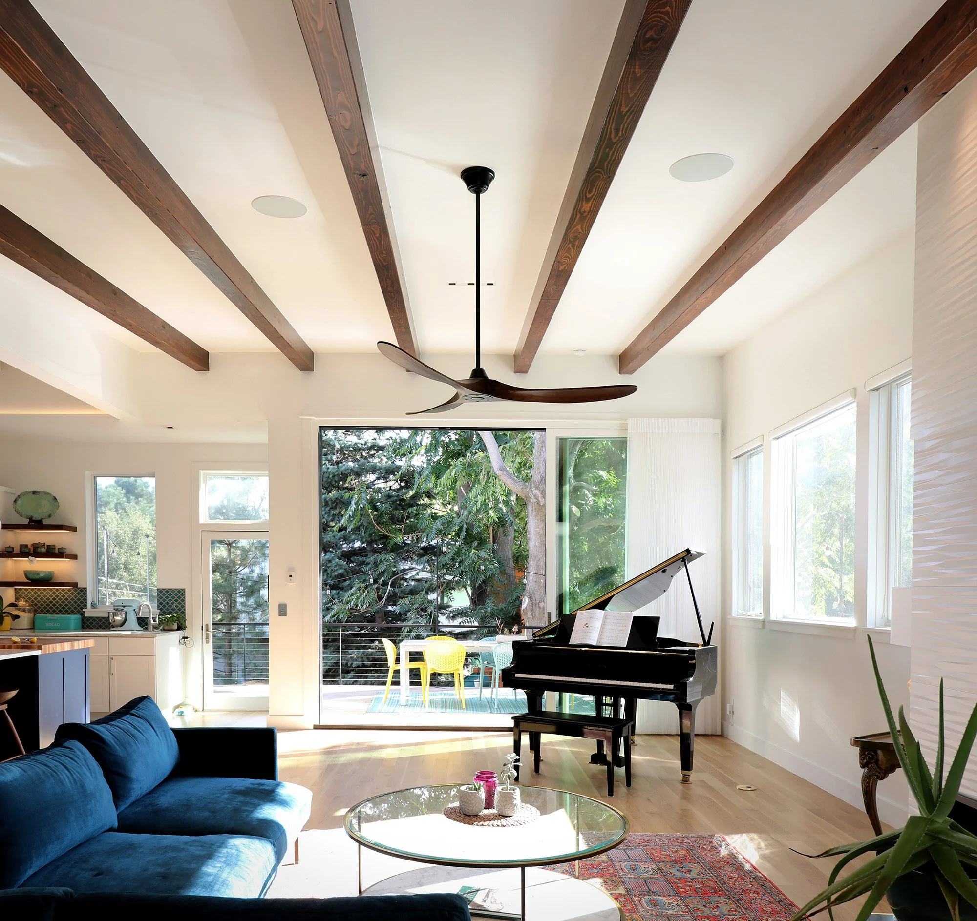 Light-filled living room of the Phototropic House featuring exposed timber beams, expansive glazing, and interior spaces oriented toward natural daylight and garden views.
