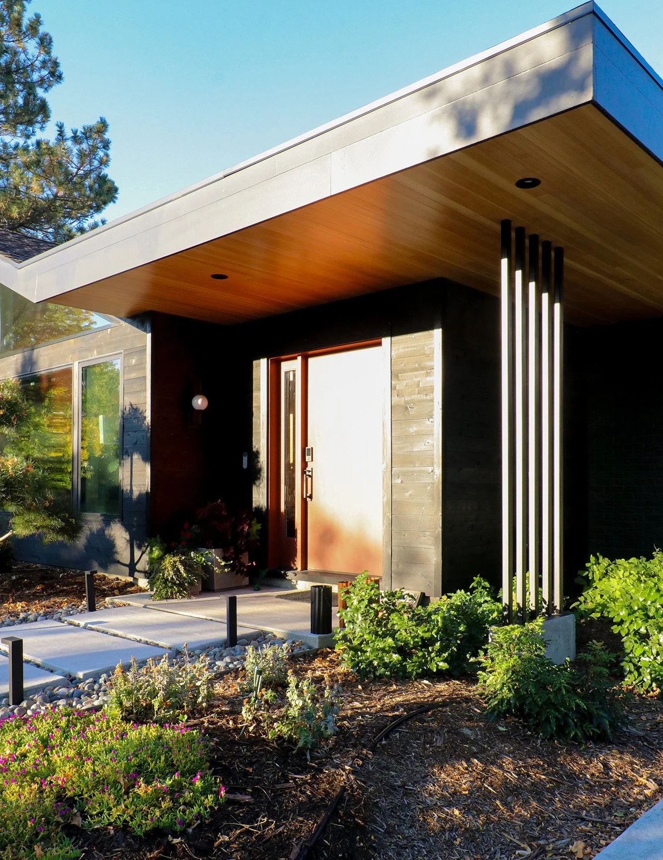 Front entry of the Canyon House, a modern Boulder custom home where layered roof planes, warm natural materials, and a sculptural entrance introduce a flowing interior inspired by canyon landscapes.