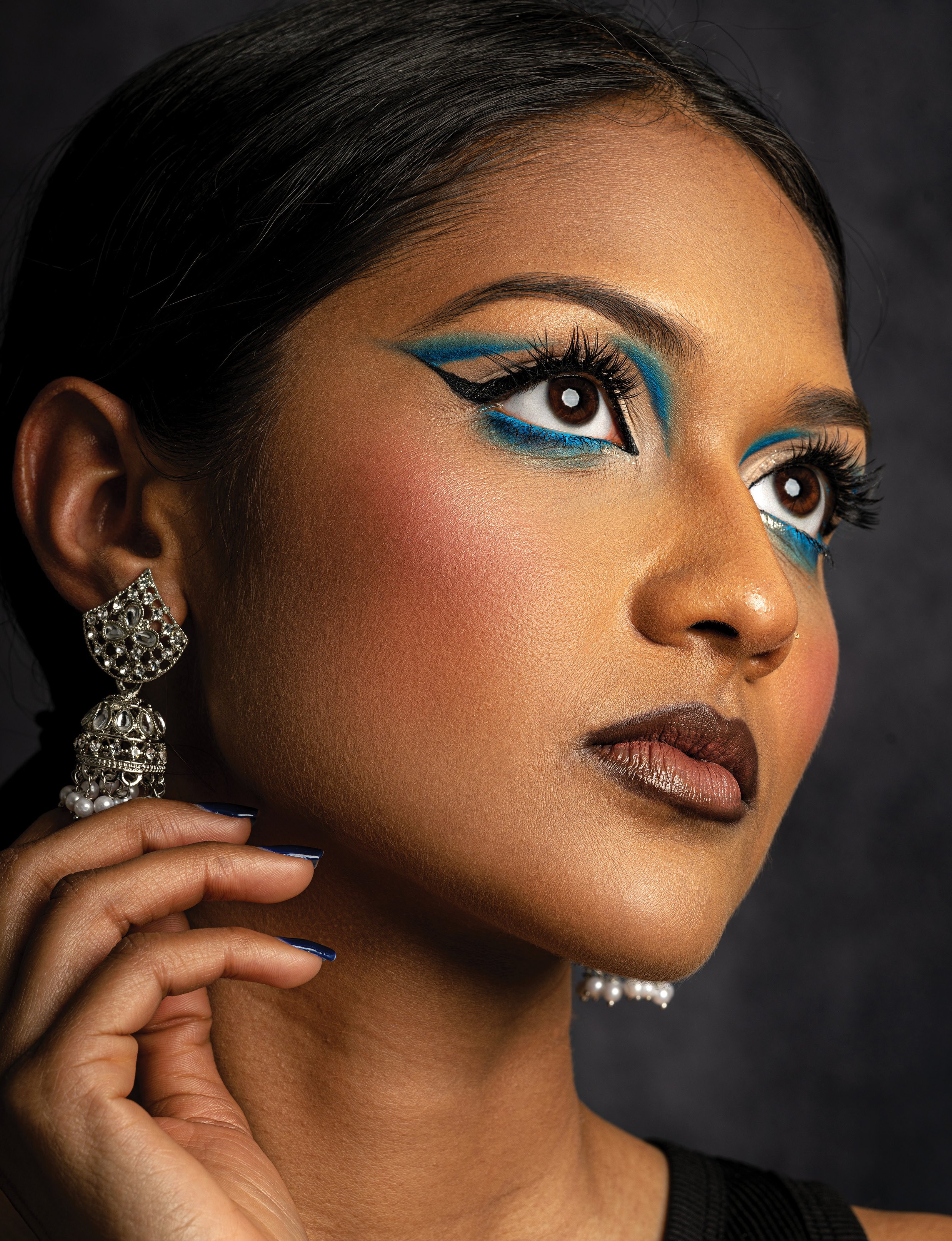 Creative beauty editorial 'Ethereal Allure' from Malvie Beauty, featuring a model with dramatic graphic blue eyeliner. Studio photography and retouching by Politan Media Group.