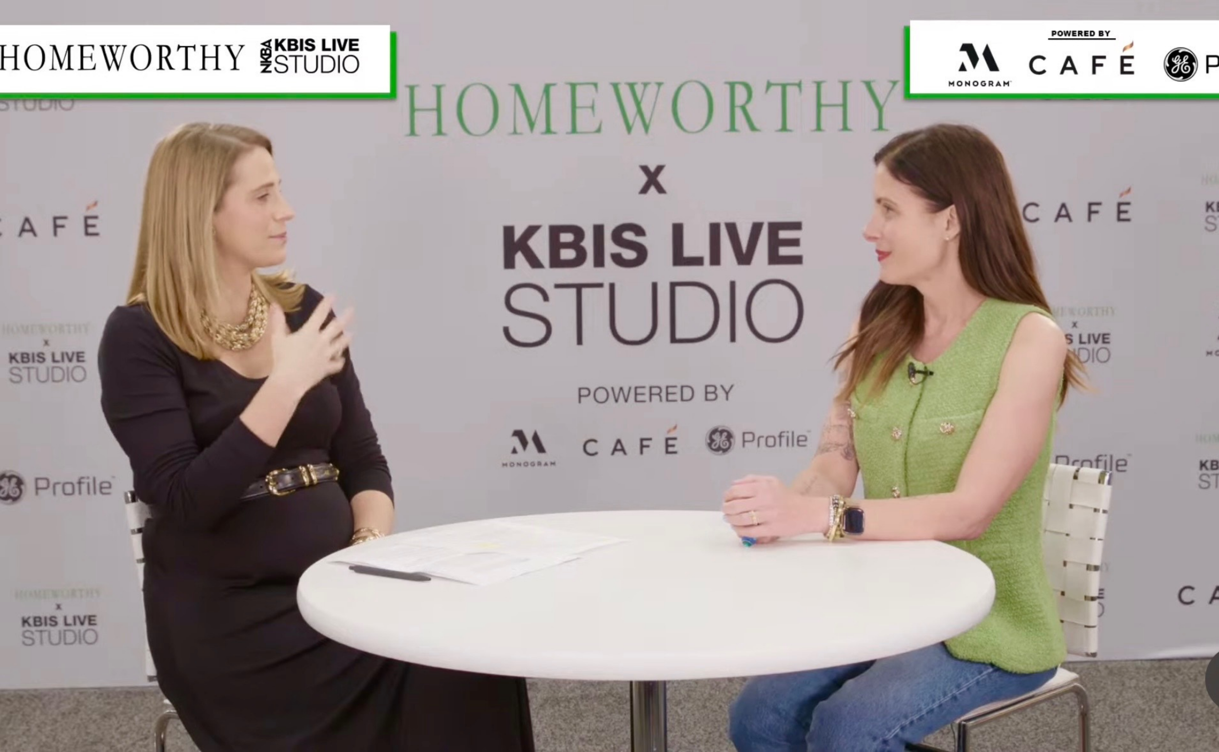 Two women sitting at a round white table during an interview or discussion, with a backdrop displaying the words 'HOMEPATHY x KBIS LIVE STUDIO' and various logos.