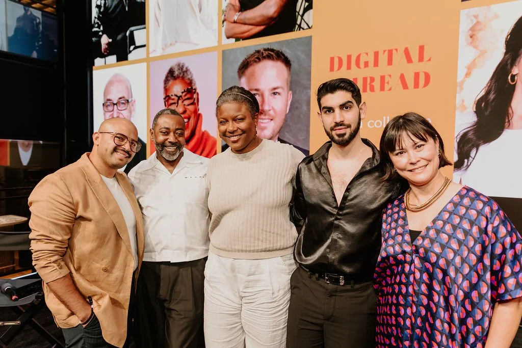 Group of six diverse people standing together at an event, smiling, with a colorful background showcasing portraits and text that reads 'Digital Read.'