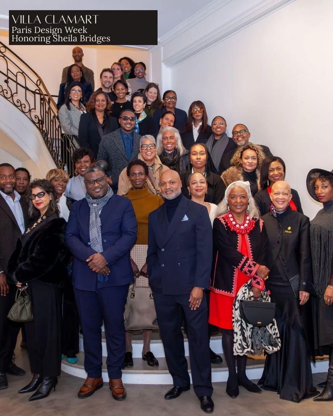 Group photo of diverse people at Villa Clamart during Paris Design Week, honoring Sheila Bridges, gathered on a staircase inside a building.