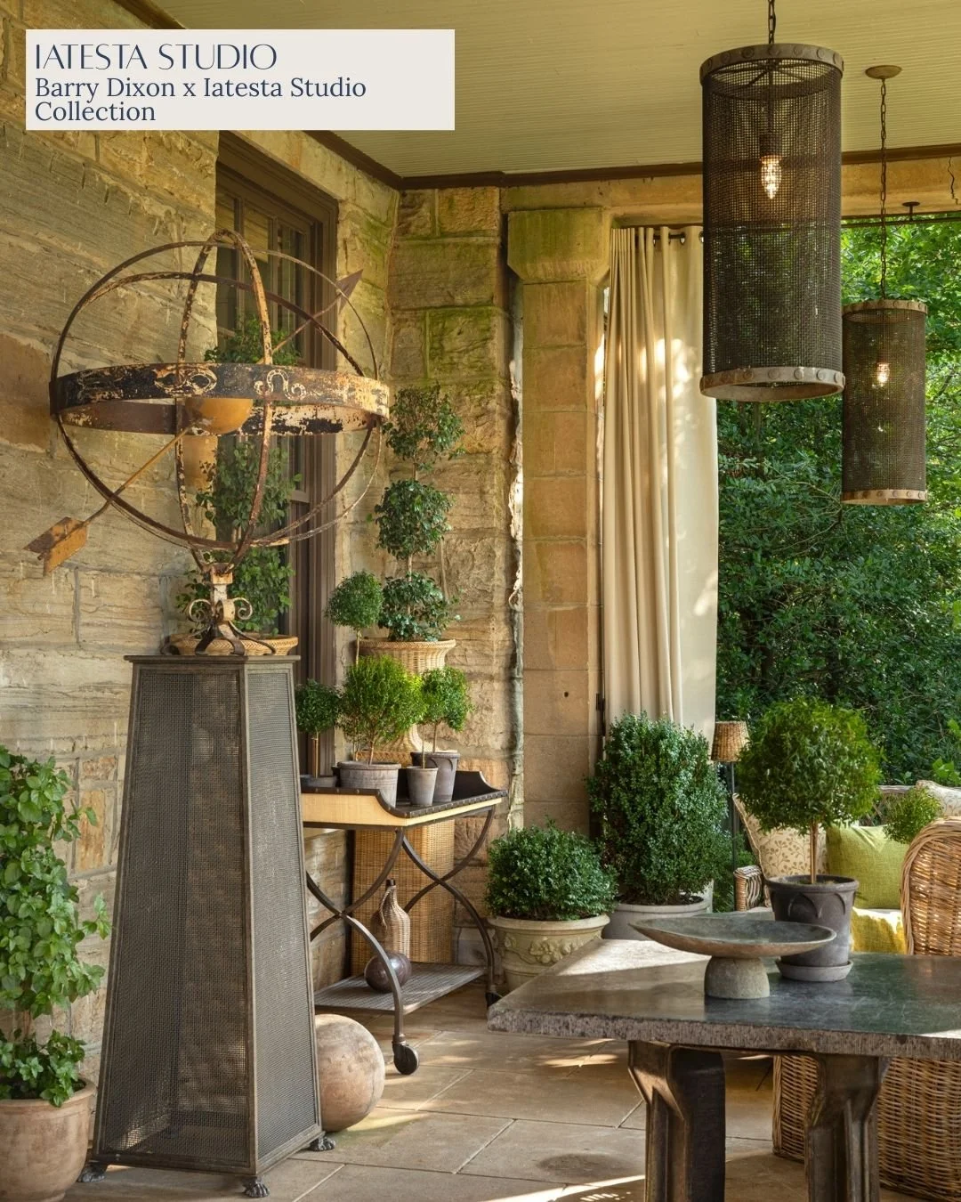 A porch or outdoor living space decorated with potted plants, stone wall, and hanging black lanterns, with sunlight filtering through trees.