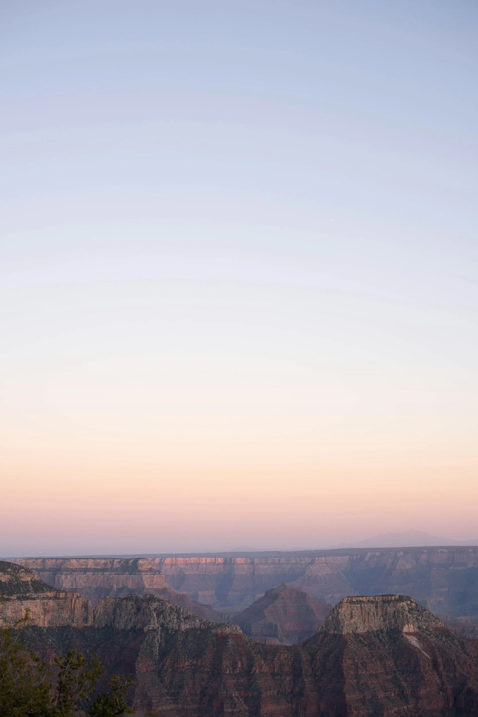Sunset over the Grand Canyon with colorful sky and layered canyon formations.