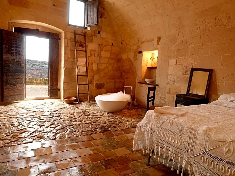 sextantio le grotte della civita italy bedroom with view.jpg
