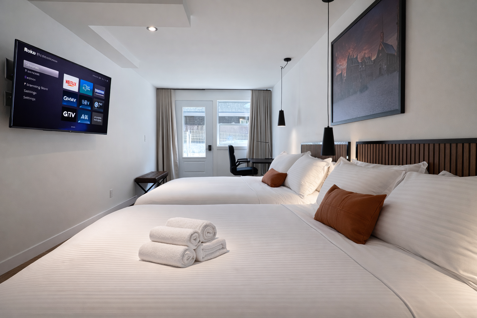 Chambre d'hôtel avec deux lits, téléviseur à écran plat, fenêtre avec vue sur l'extérieur, décor moderne avec tableau accroché au mur.