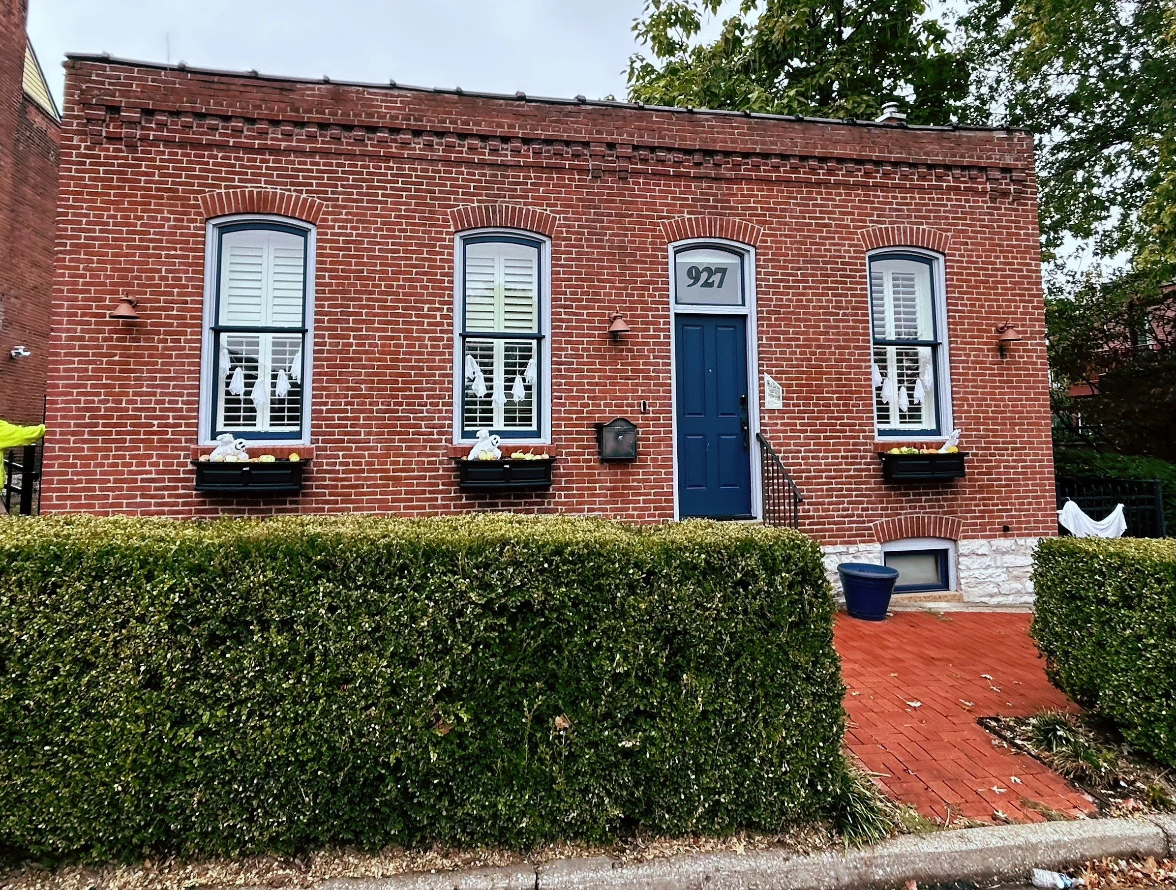 A landscape scene of a large lake surrounded by grassy hills and mountains under a cloudy sky.