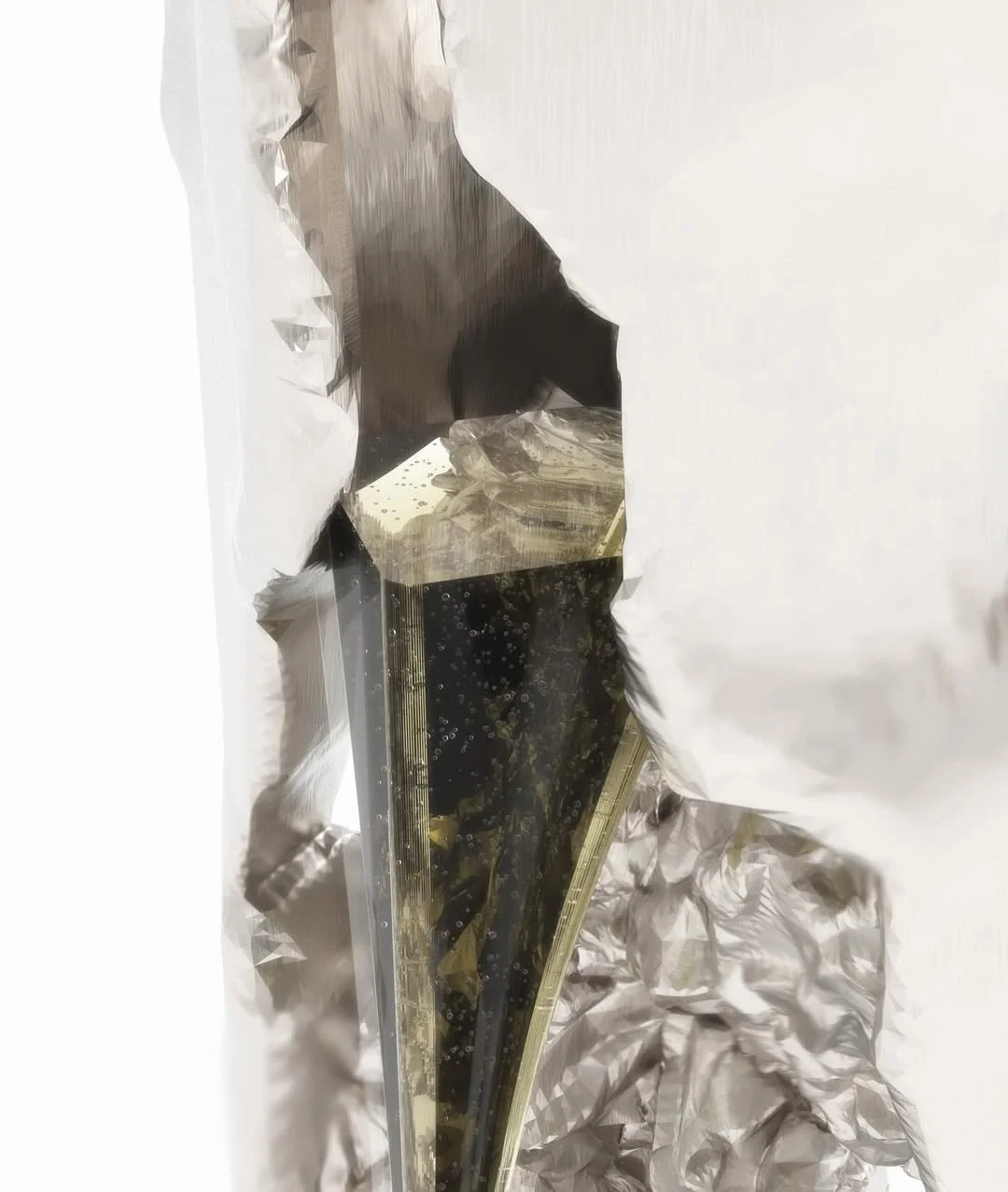 A feline in a black and white coat peering into a slice of cheesecake on a foil tray with crinkled aluminum foil around it.