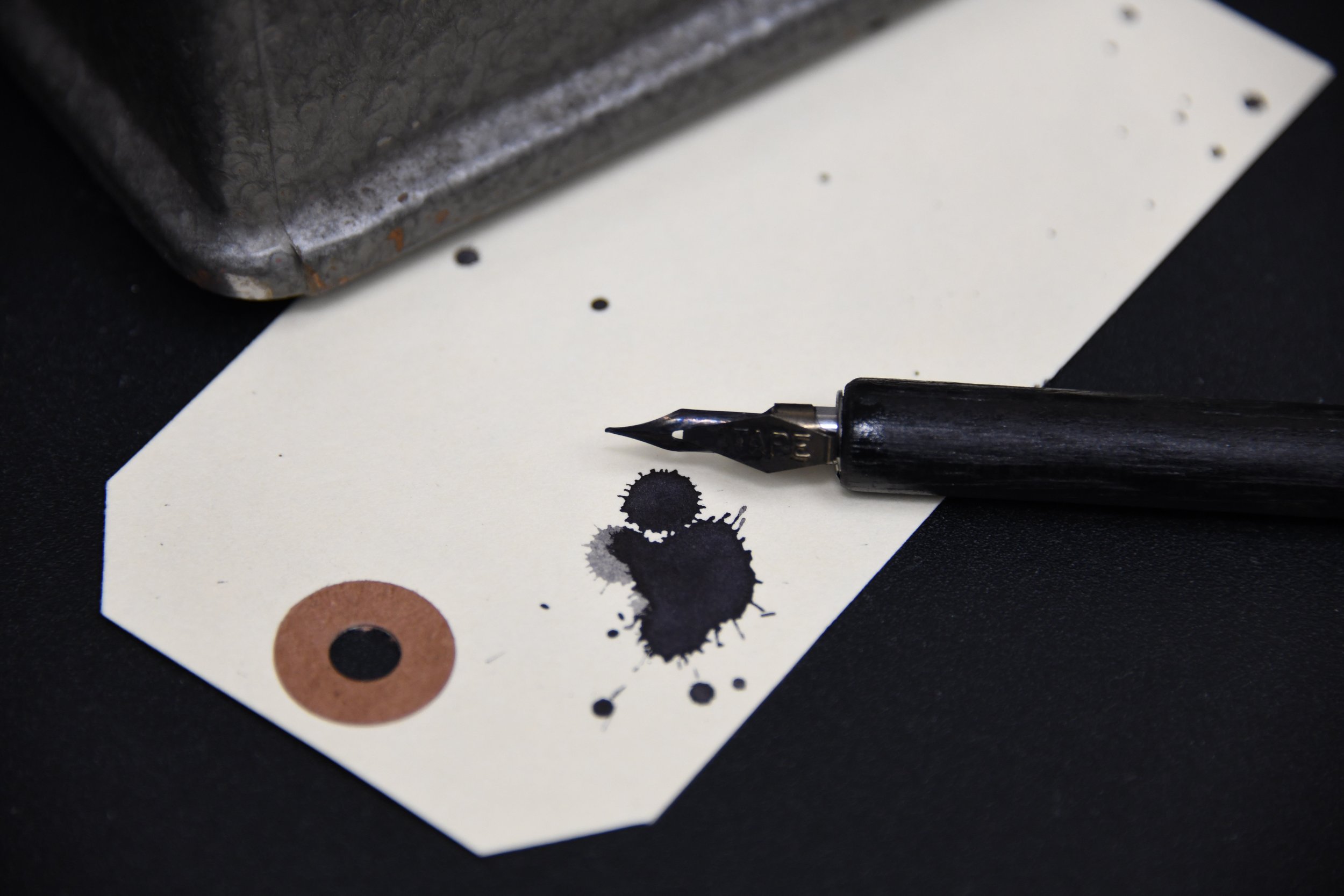 Pen and ink blotches on a blank piece of paper