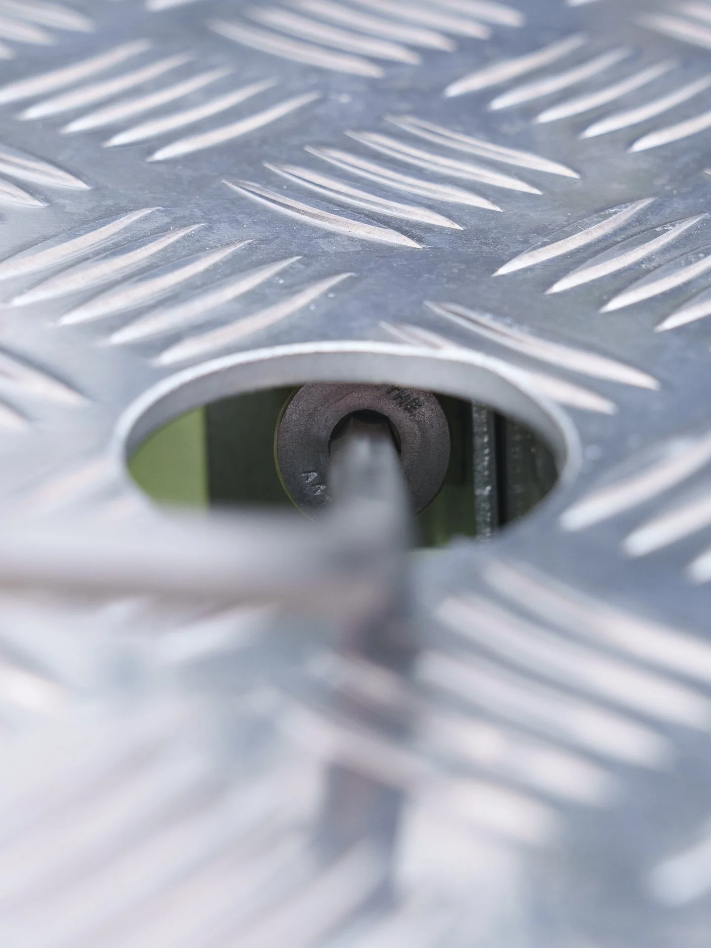 Close-up top view of an aluminium bore cover secure locking mechanism, bolt.