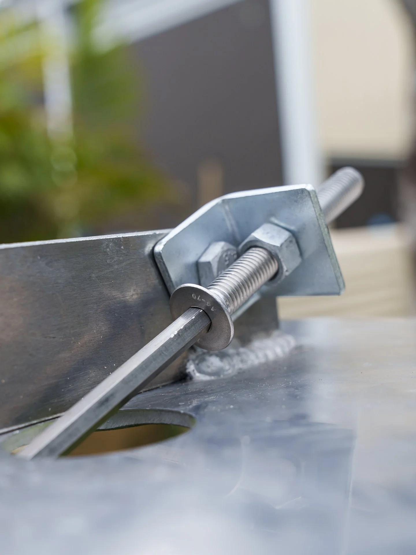 Close-up side view of an aluminium bore cover secure locking mechanism, bolt and allen key tool.
