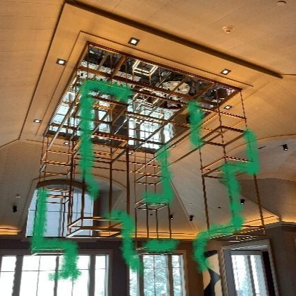Interior room with drop ceiling and construction scaffolding in the ceiling opening, green spray paint markings on the scaffolding.