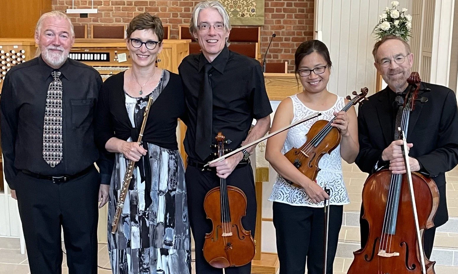 Richmond Chamber Players. A group of five musicians in formal attire holding instruments in a church or concert hall.