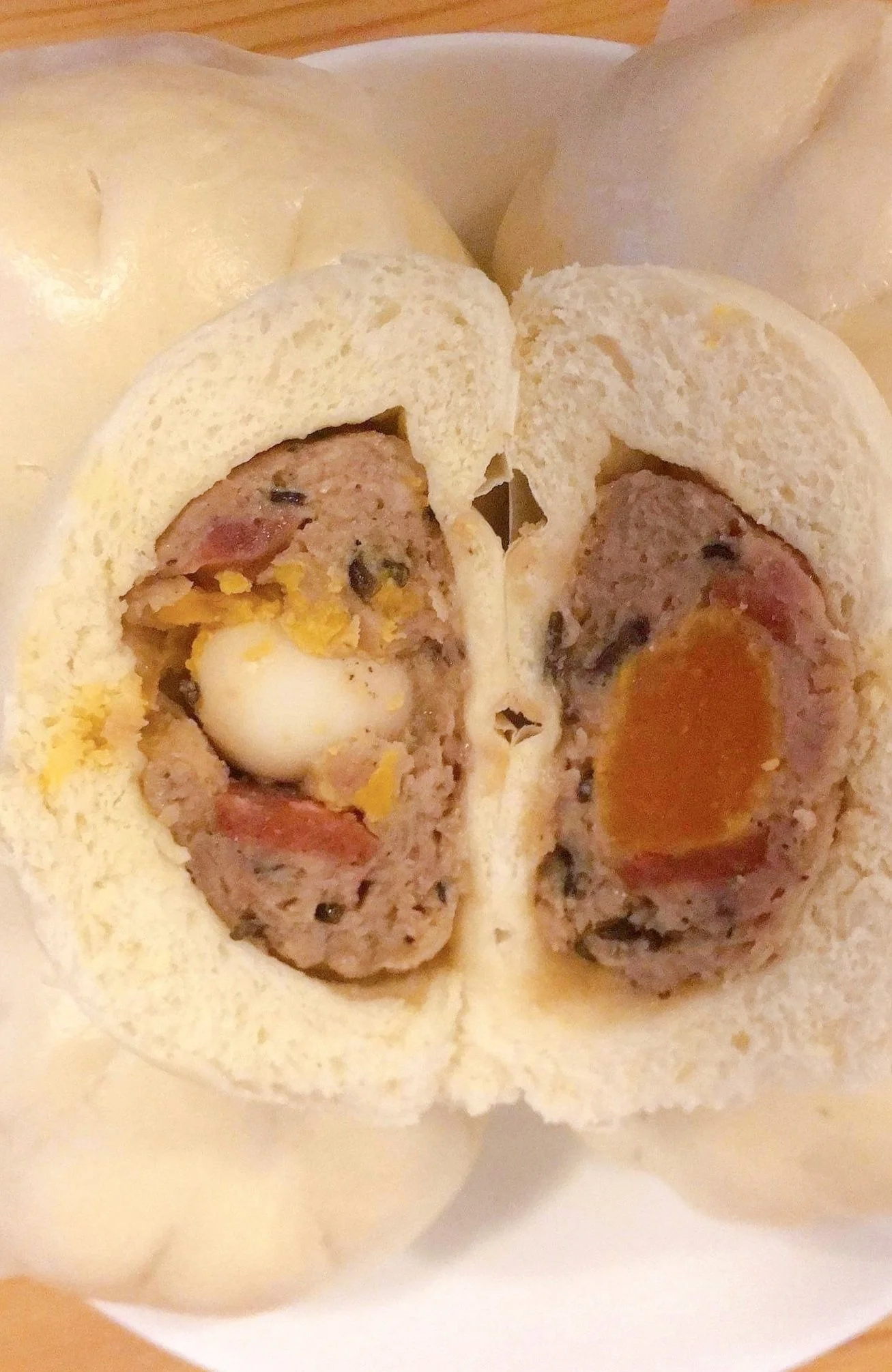 Cross section of a steamed bun filled with meat, egg, and a soft camping egg yolk