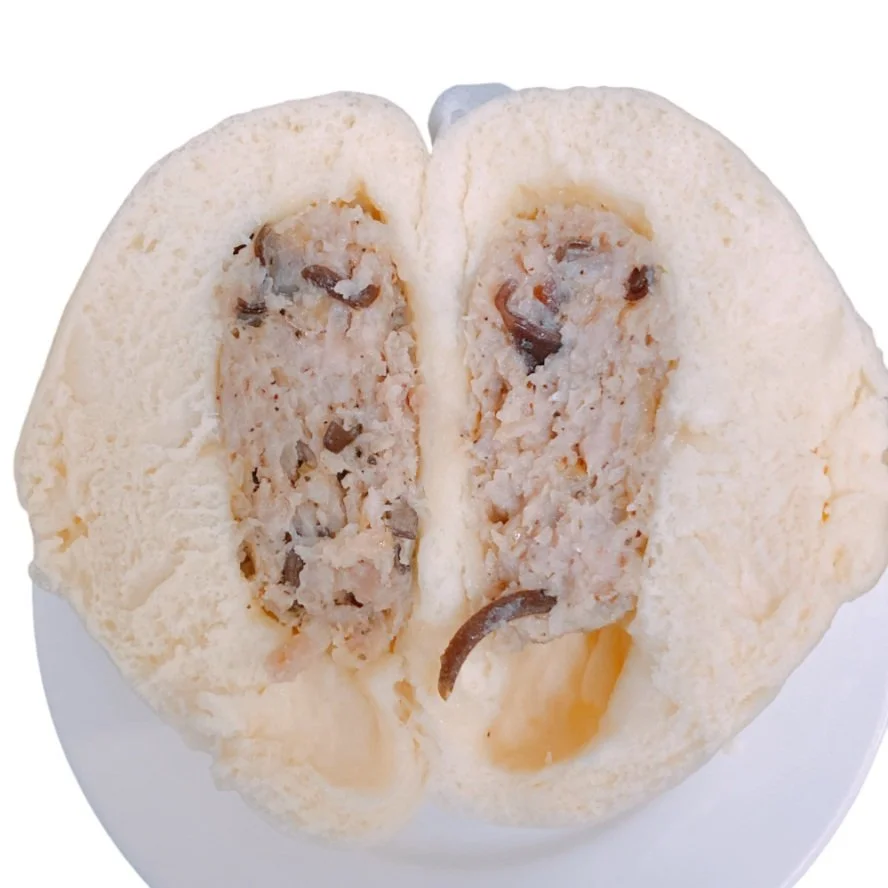 Cross-section of a steamed bun filled with a savory mixture containing ground meat and mushrooms.