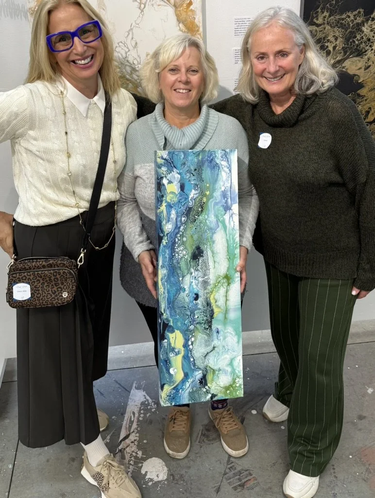 Cheryl Wheeler with a collector holding a blue and green abstract painting