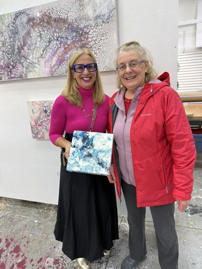 Cheryl Wheeler with a collector holding a small blue abstract painting