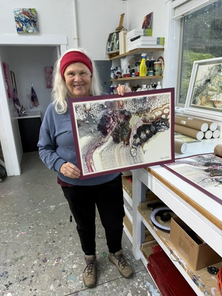 Collector holding a framed abstract artwork in Cheryl Wheeler’s studio