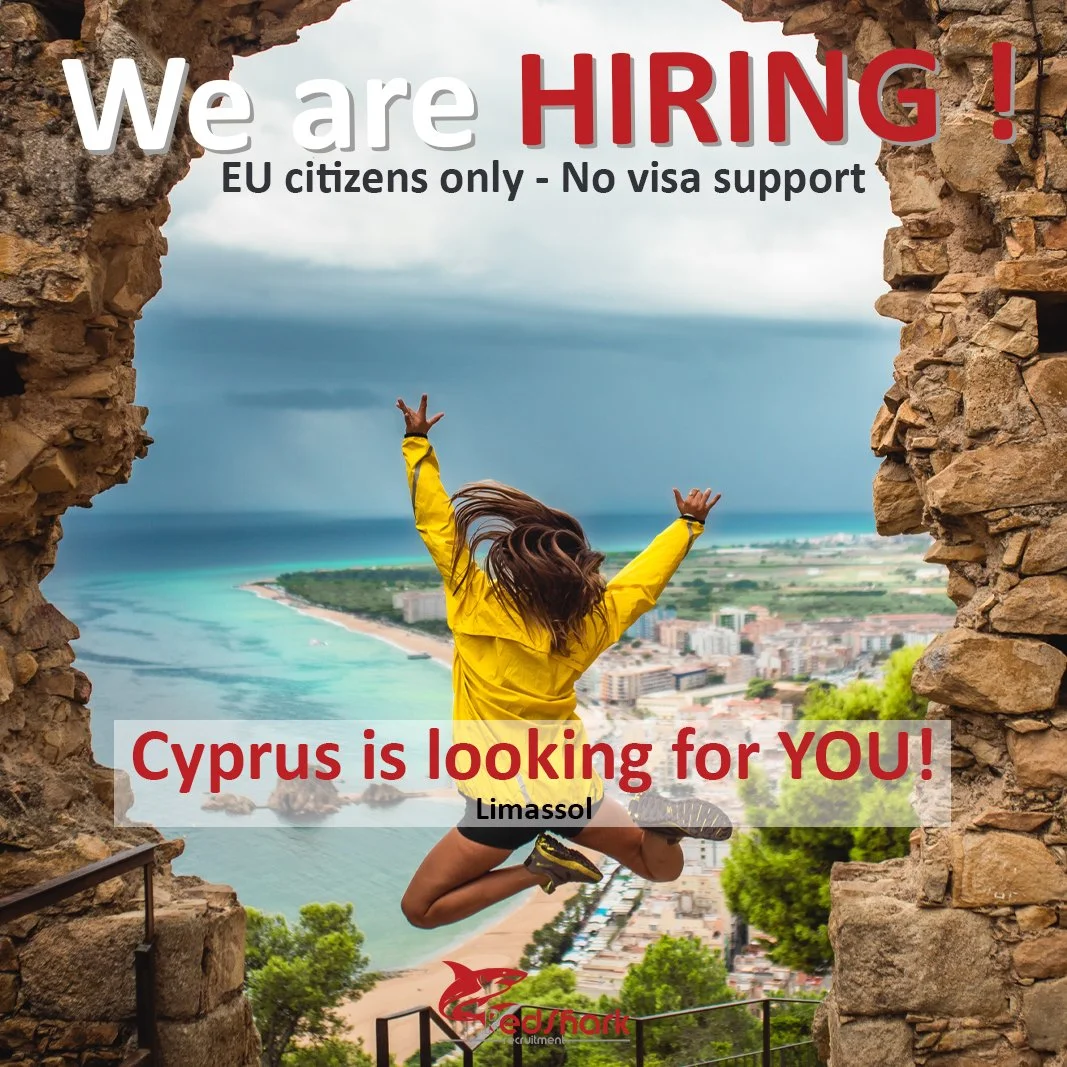A woman in a yellow jacket jumping in front of a scenic view of the coast, with rocky framing on either side, promoting a job opening in Cyprus for EU citizens.