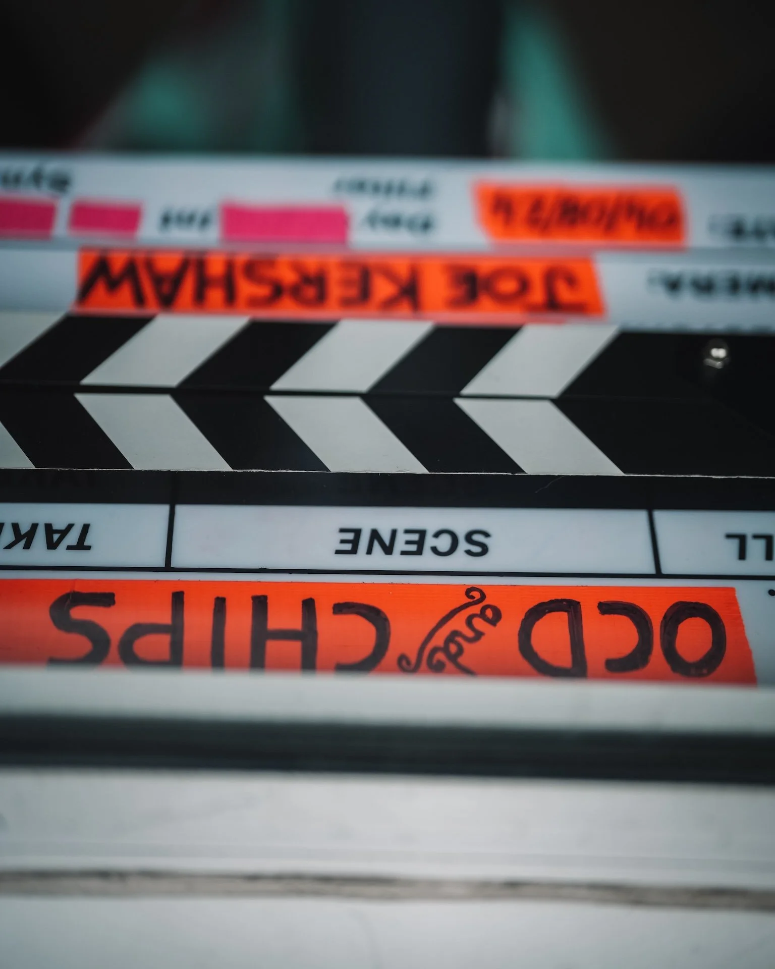 Close-up view of a film slate or clapperboard with the words 'DOD SHIP' and 'OS' visible, used in film production to mark scenes and takes.