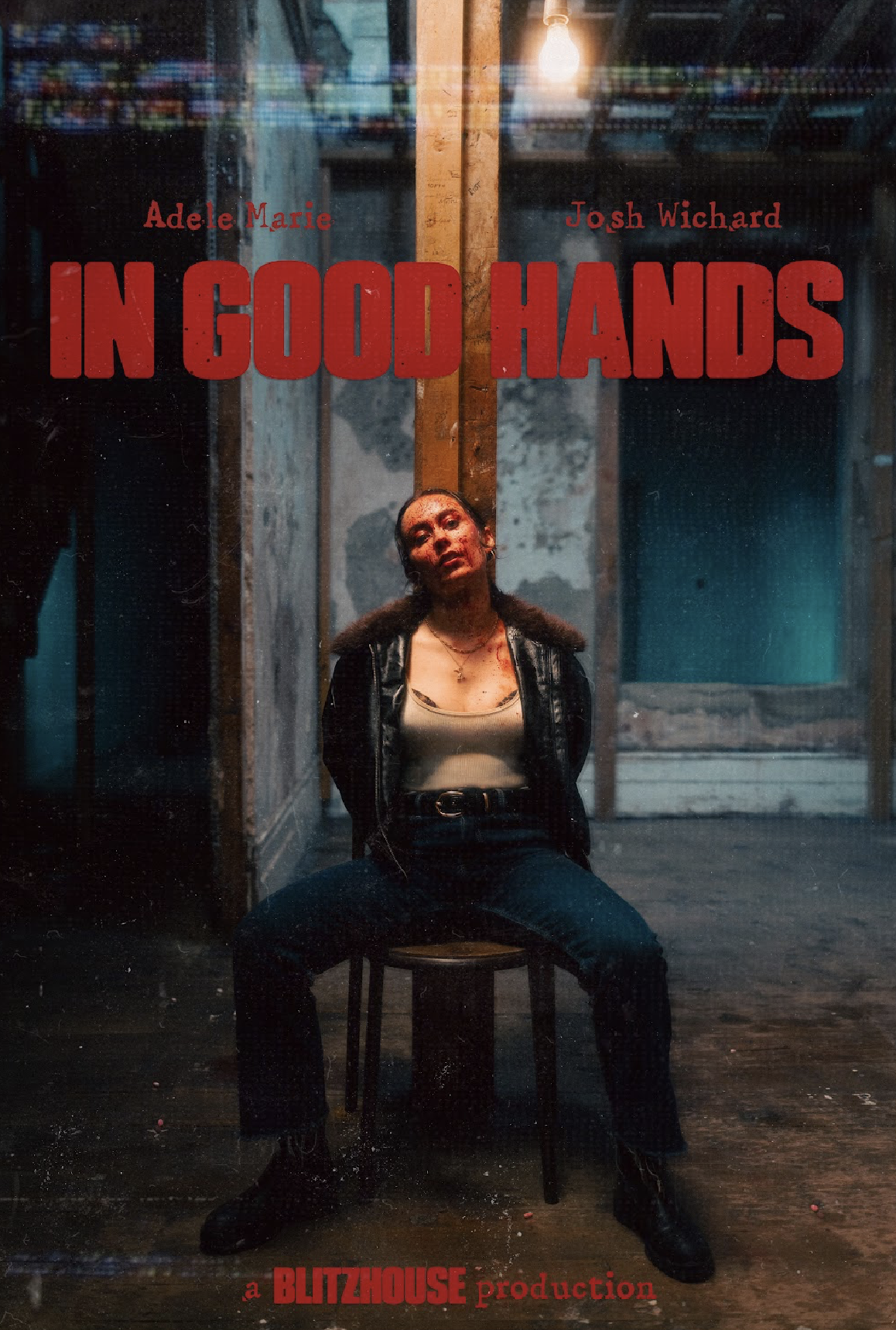 A woman with dark hair and a leather jacket, sitting on a chair in a dimly lit room with an exposed light bulb. She is looking up with a serious expression. The background features wooden panels and a worn interior. Text on the image includes the title 'IN GOOD HANDS' and the names 'Adele Marie' and 'Josh Wichard,' with production credits at the bottom.