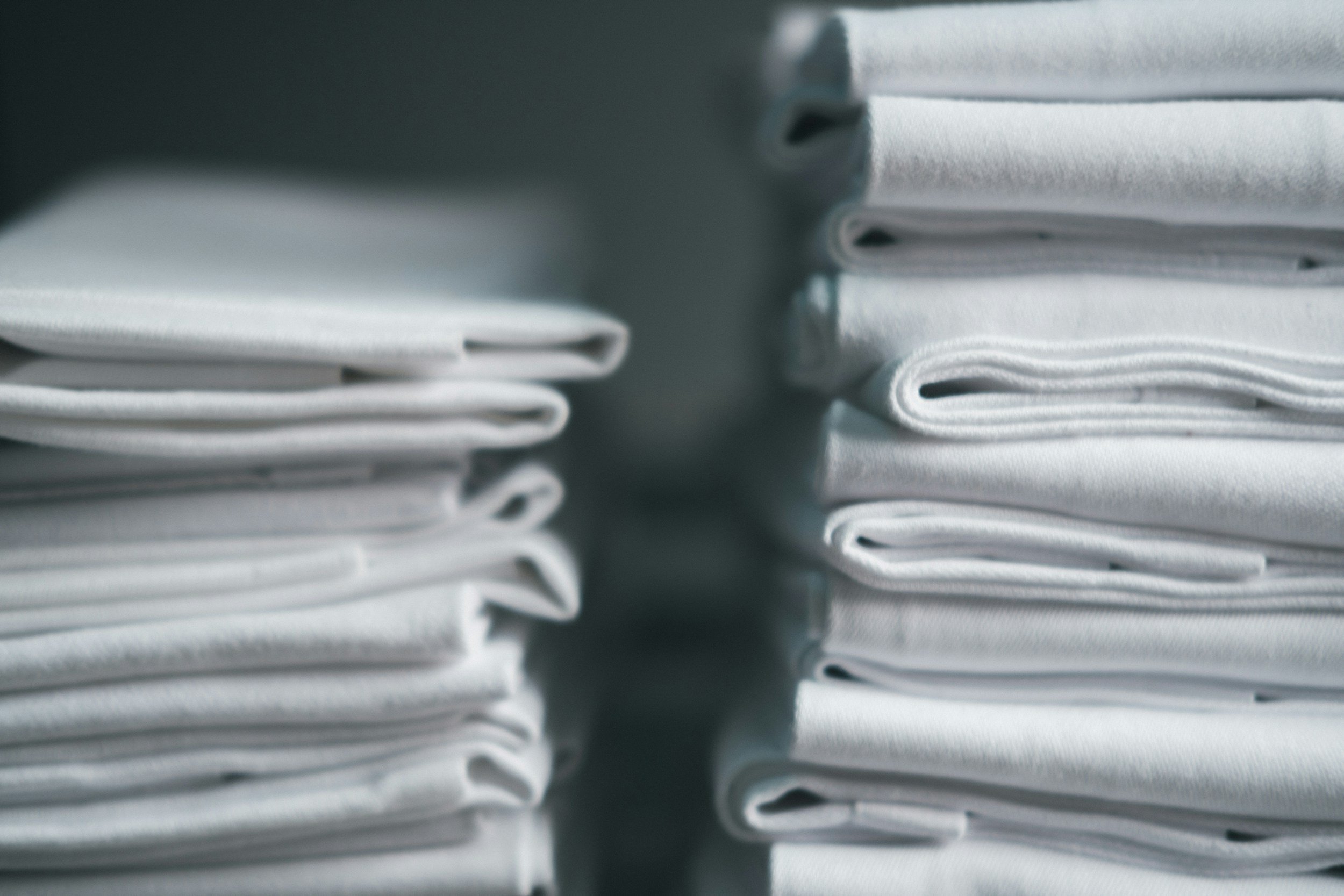 Stacks of white folded towels arranged in two columns.