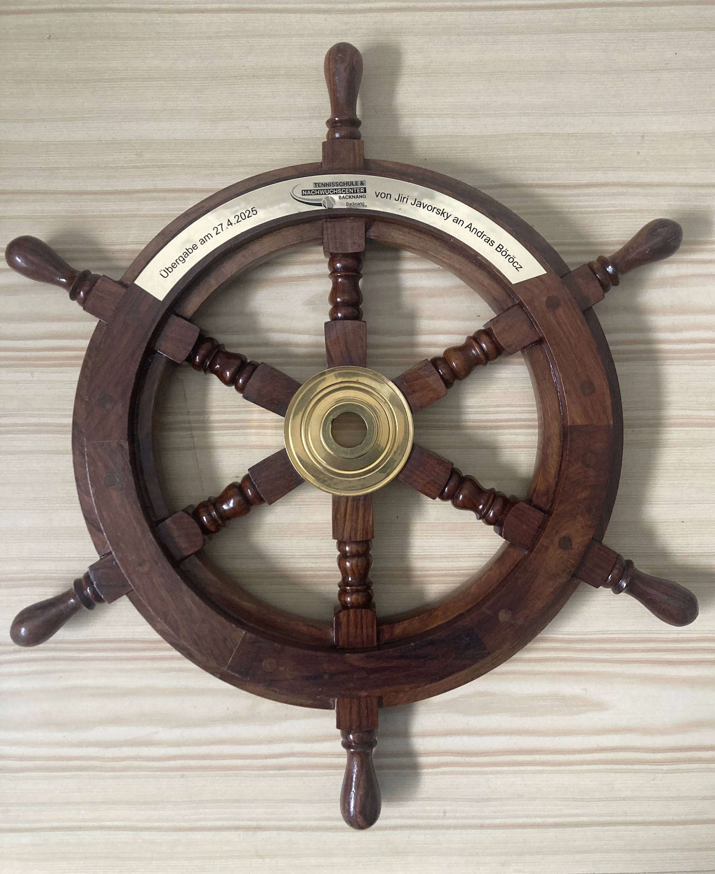 Ein Wandkunstwerk, das aussieht wie ein Schiffsruder mit einem Seekreuz in der Mitte