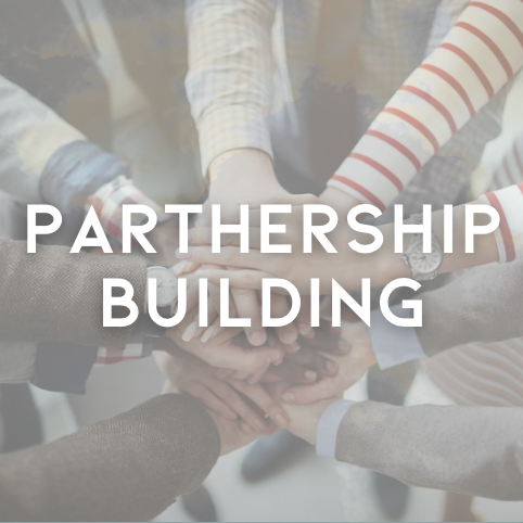Multiple hands stacked together, symbolizing teamwork and partnership.