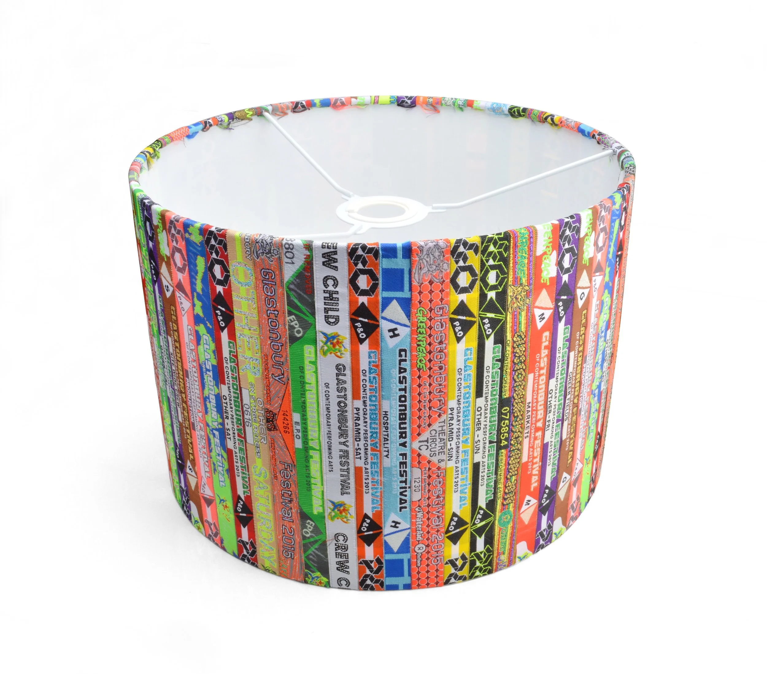 A cylindrical lampshade made from colorful recycled festival wristbands.
