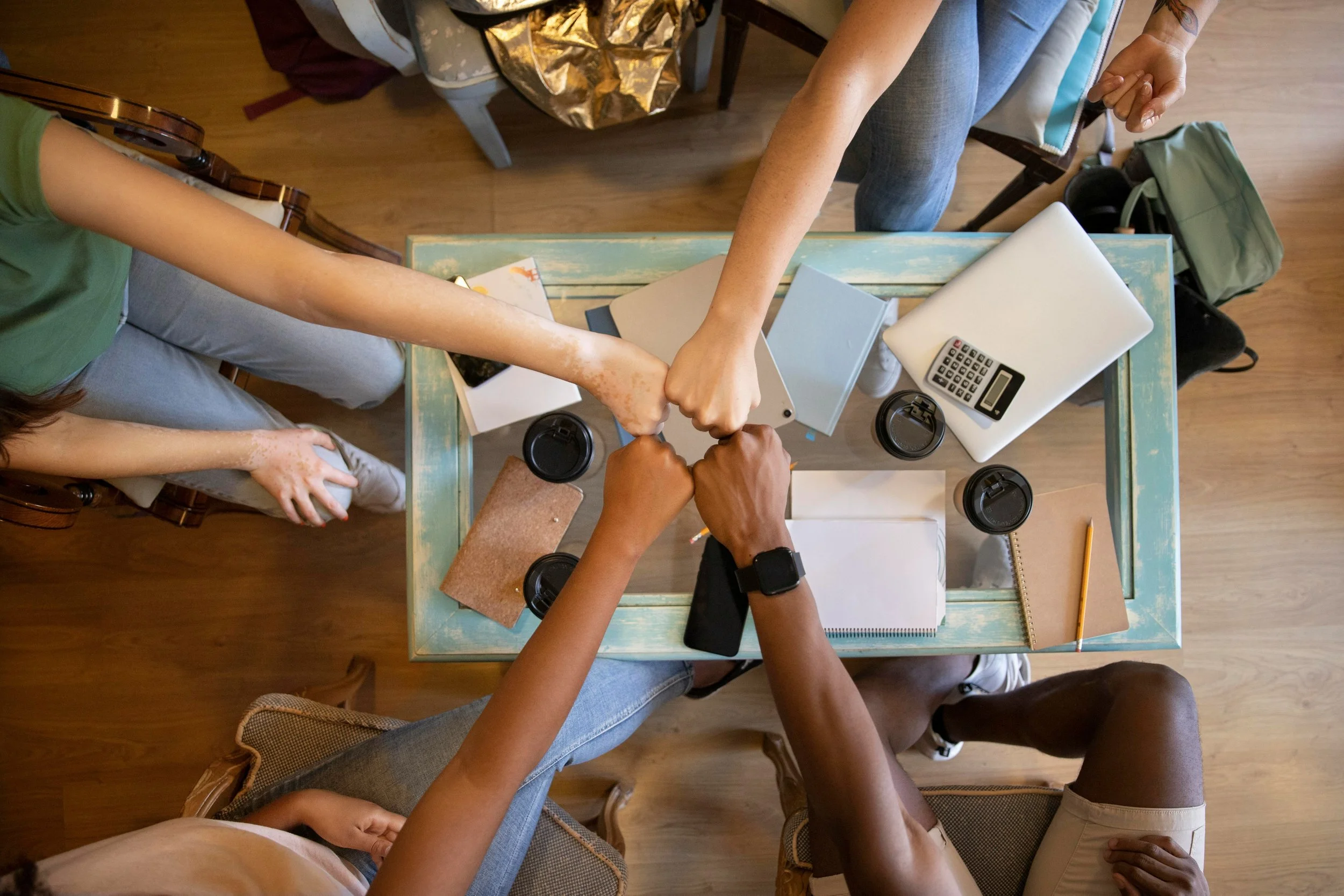 Photo by <a href="https://unsplash.com/@reazonsraj?utm_content=creditCopyText&utm_medium=referral&utm_source=unsplash">Raj Tuladhar</a> on <a href="https://unsplash.com/photos/a-group-of-people-holding-hands-over-a-table-nil1zgH28dc?utm_content=credi