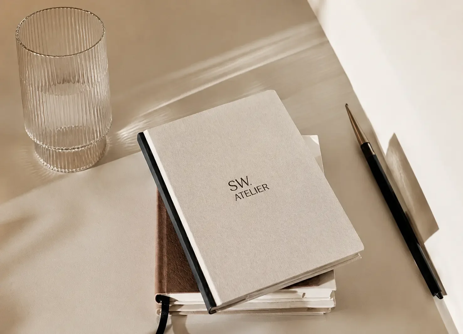 SW. Atelier branding med notesbog og minimalistisk kontormiljø
