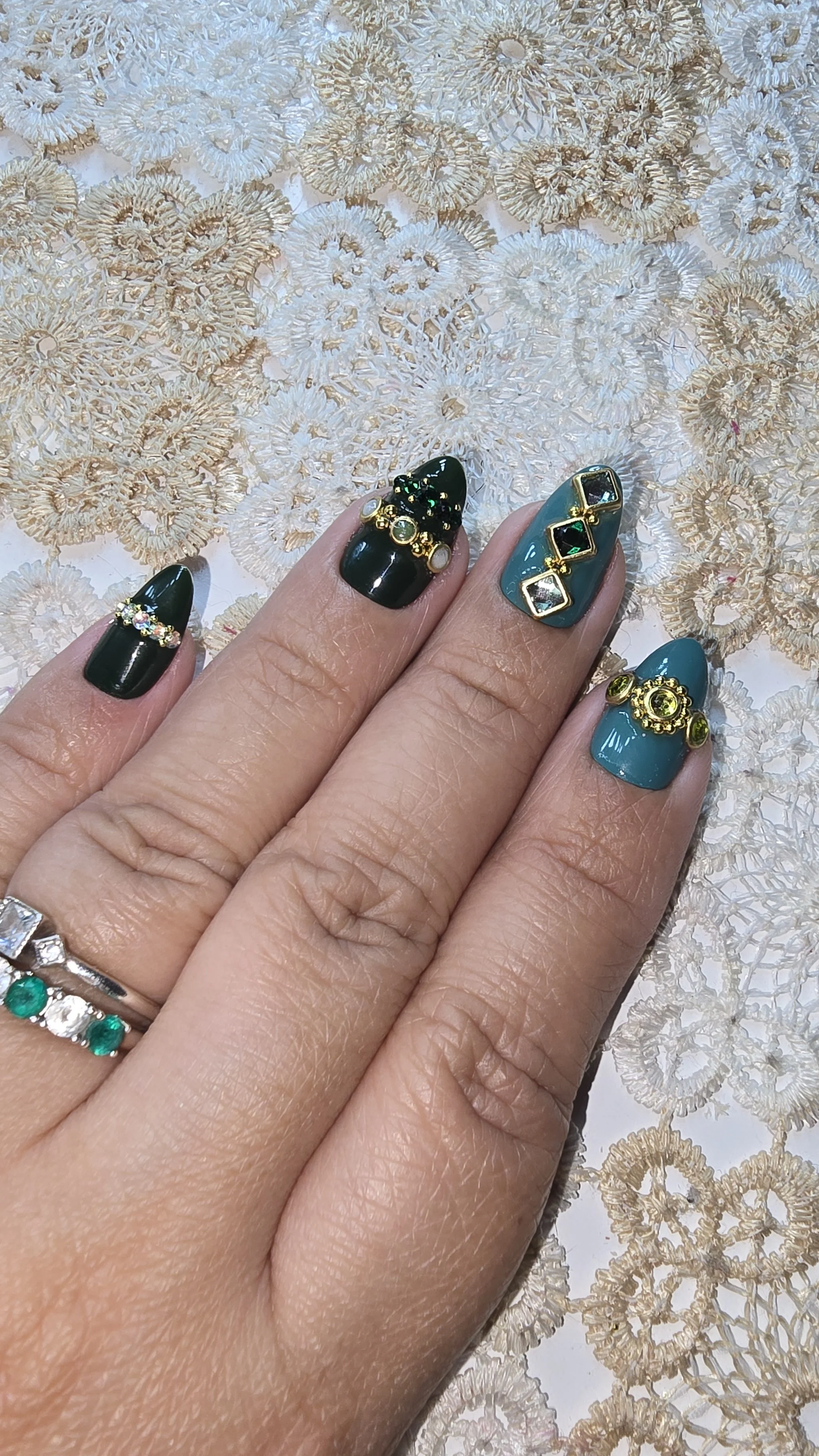 Green shade nails with gemstones in different patters on the nails; bling nails.