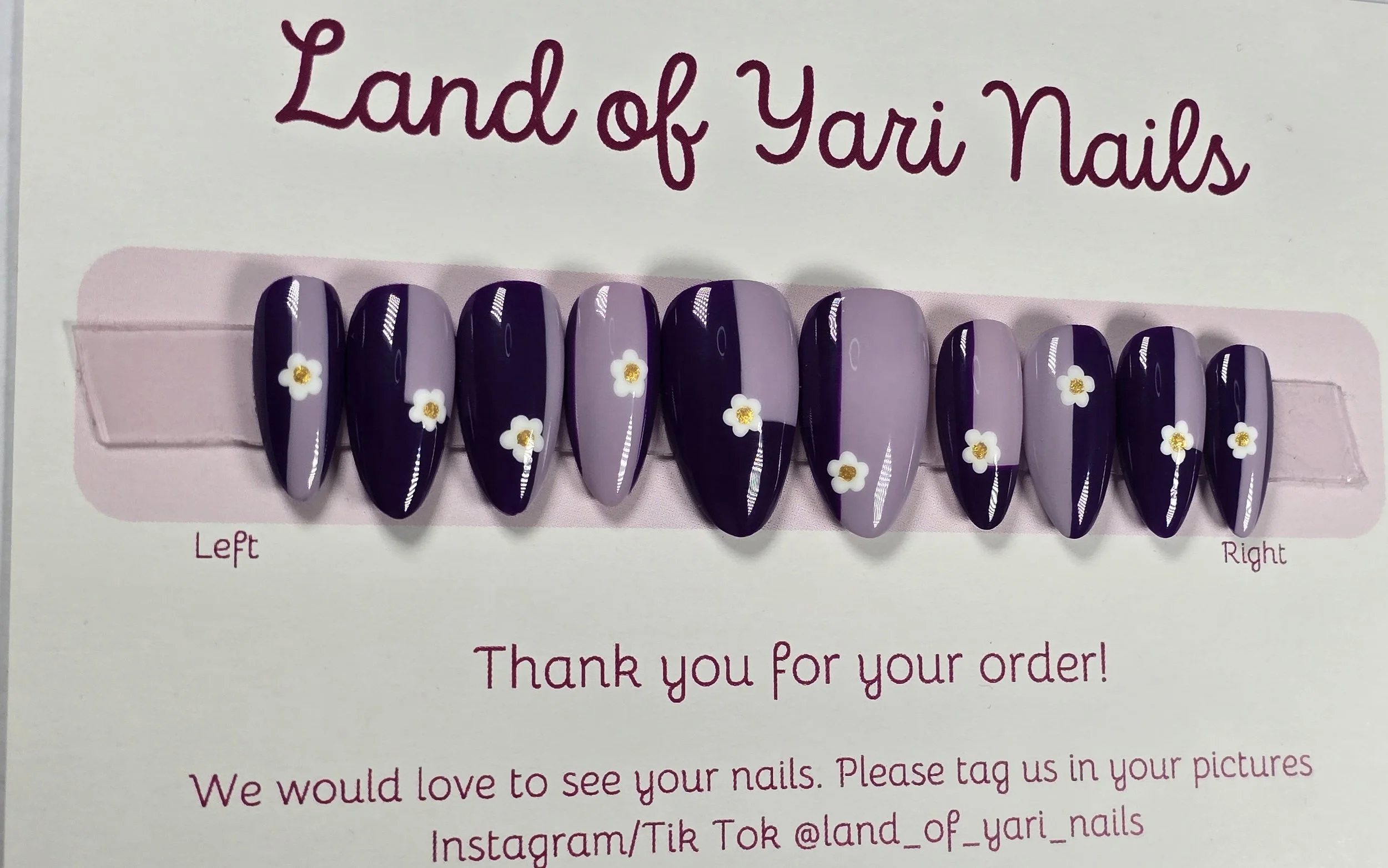 medium-almond-nails-with-purple-shade-lines-colorblocking-wtih-white-flowers-and-gold-center