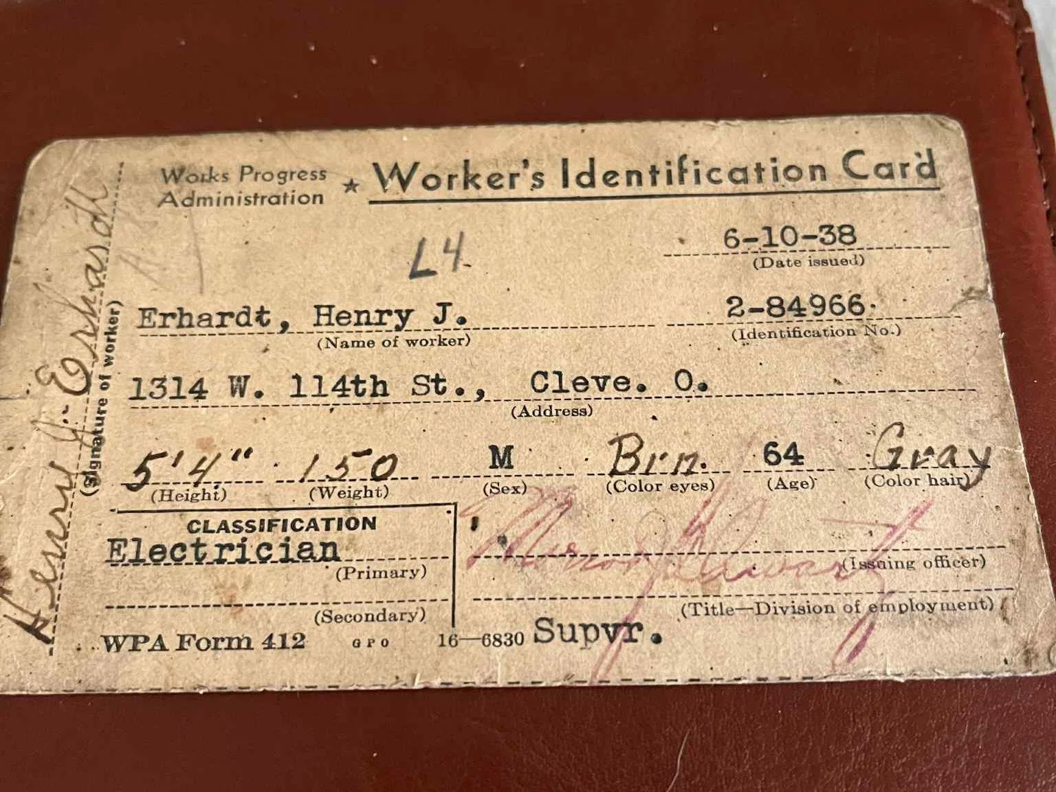 Vintage worker's identification card issued to Henry J. Erhardt, from Cleveland, Ohio, dated October 6, 1938. It includes personal details such as height, weight, sex, eye color, age, and hair color, with classification as electrician.