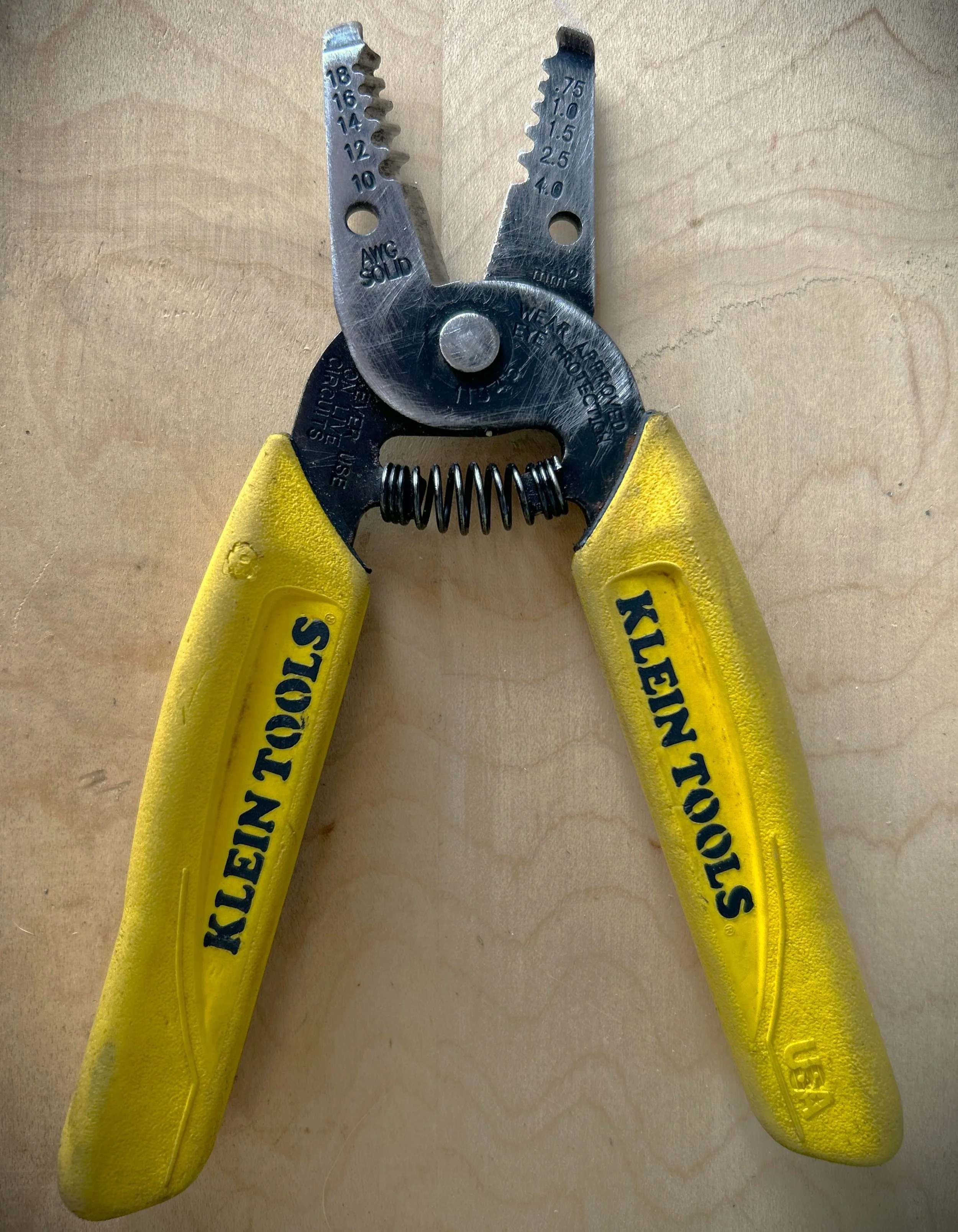 Klein Tools wire stripping pliers with yellow handles.