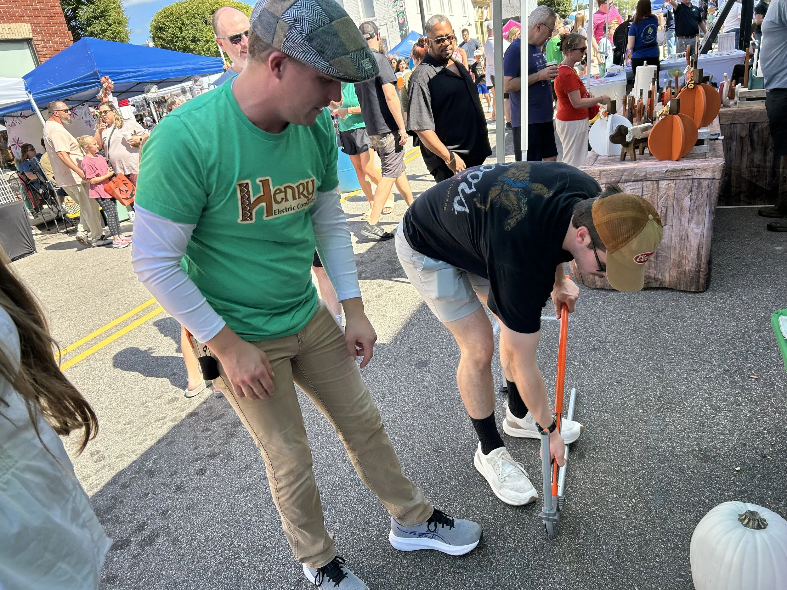 John Flood engaging in teaching individuals how to bend conduit at the Wendell Harvest Festival