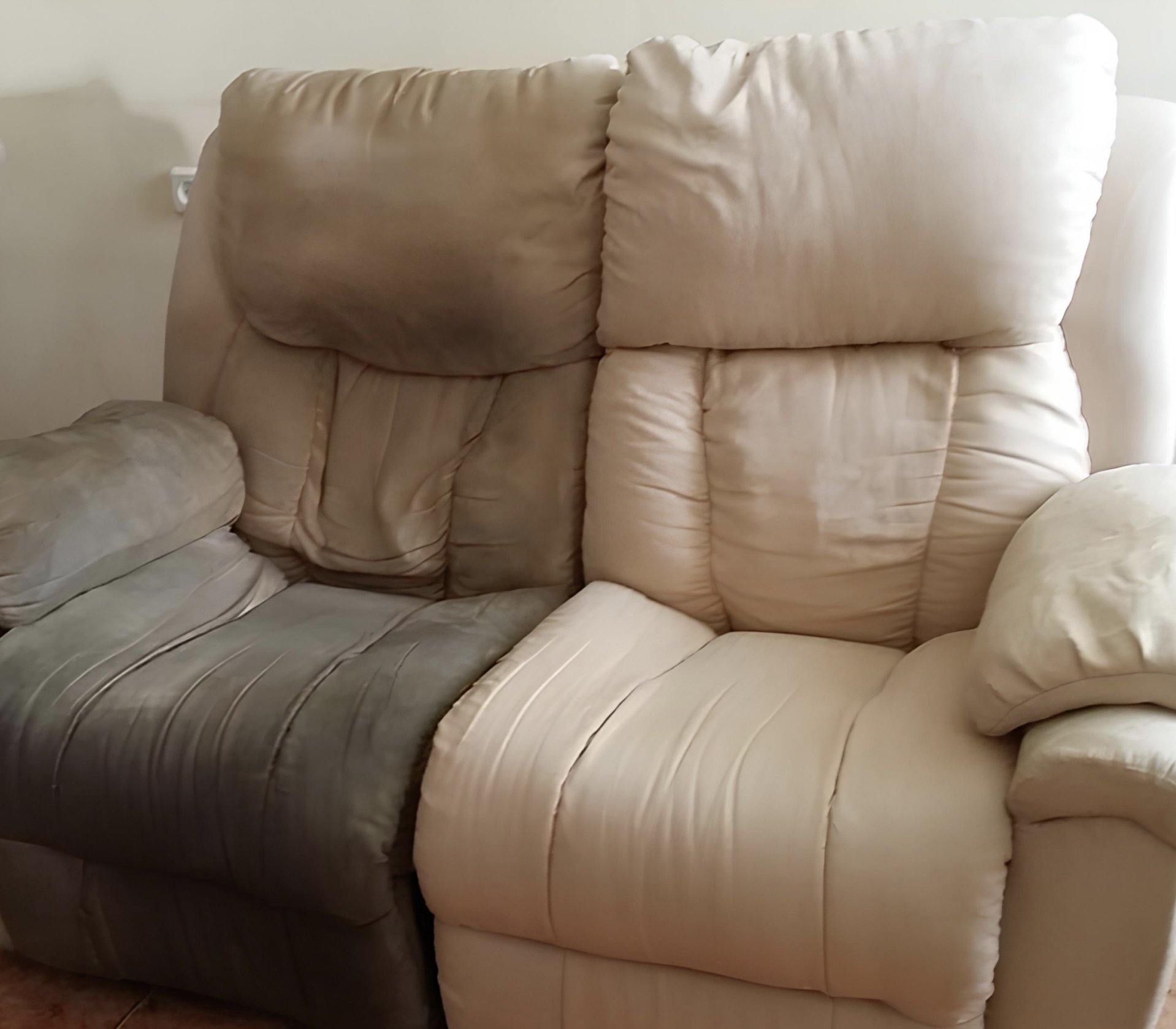 Two-tone sofa with beige and light gray upholstery, showing signs of wear, in a living room setting.