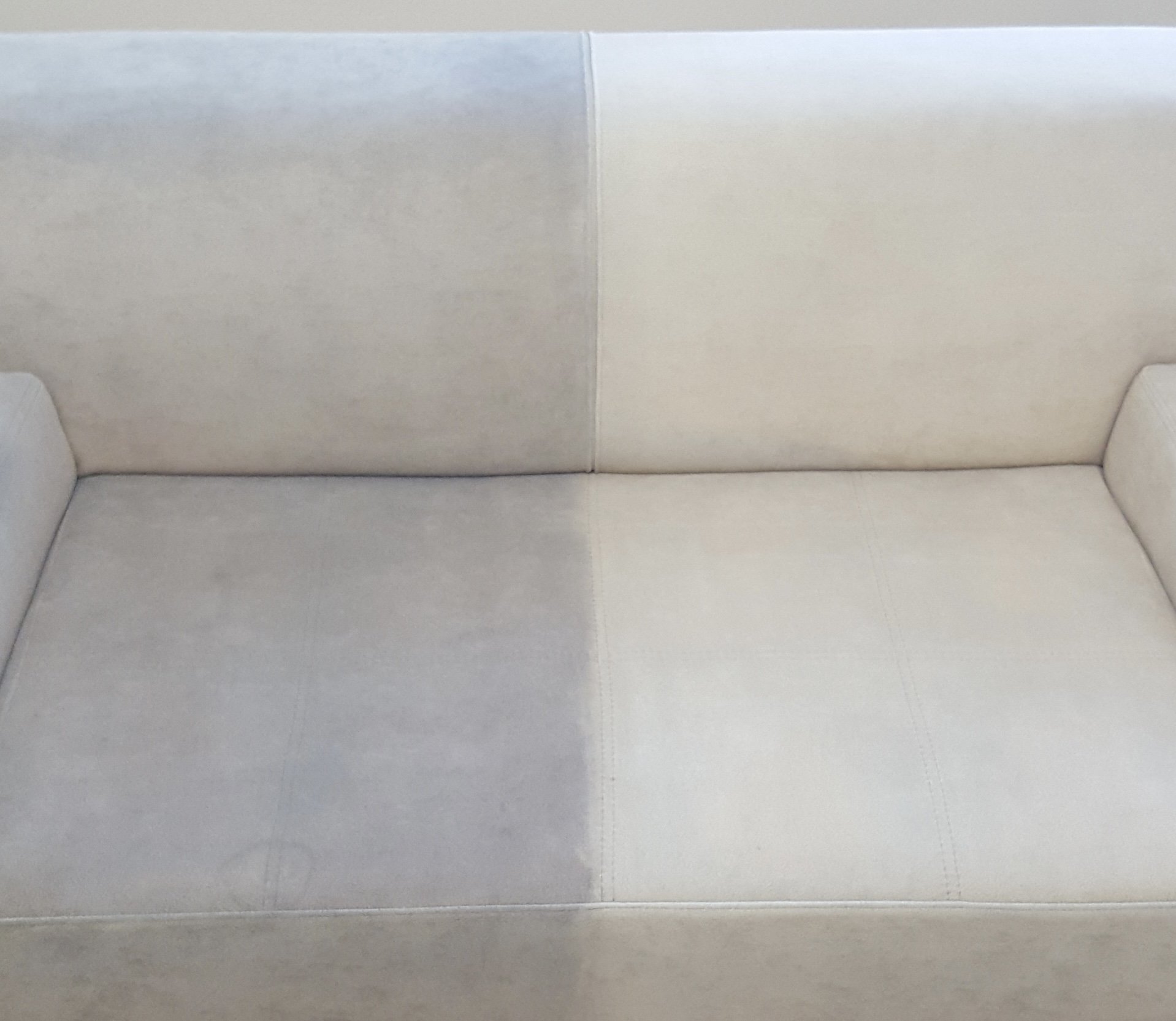 A two-seater beige or light-colored fabric couch with a simple, modern design.