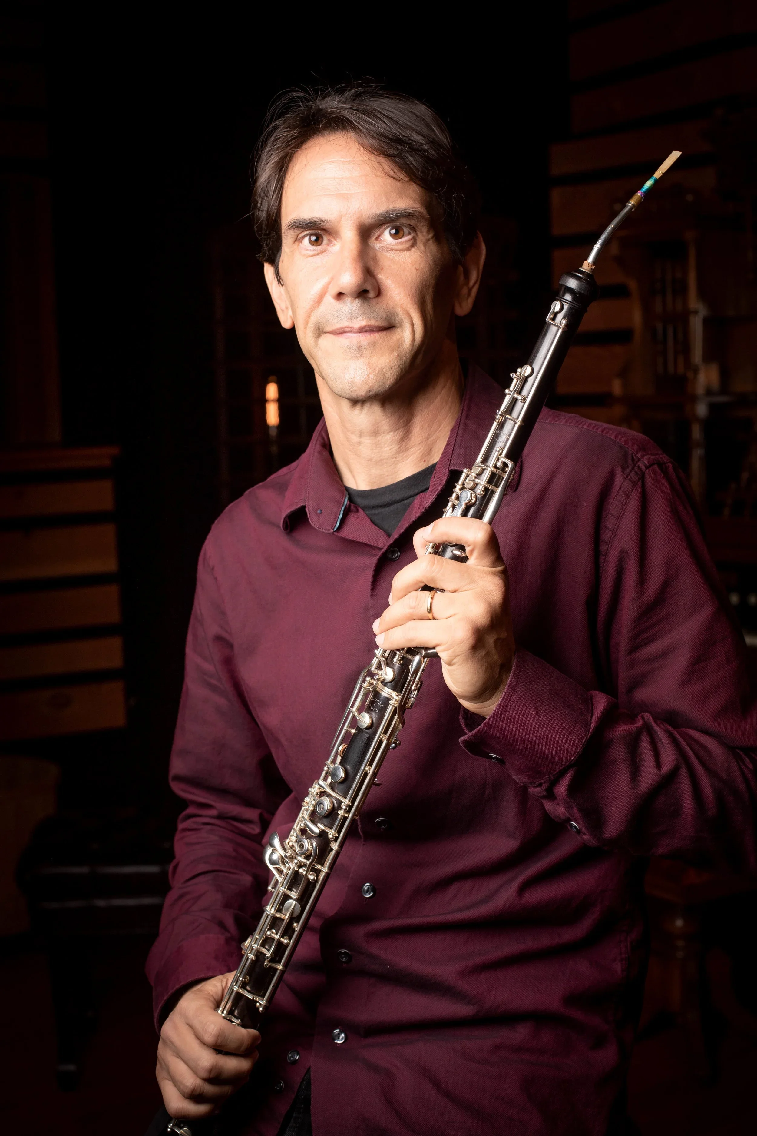 Matt Renzi. A man with dark hair holding a clarinet in a music studio.