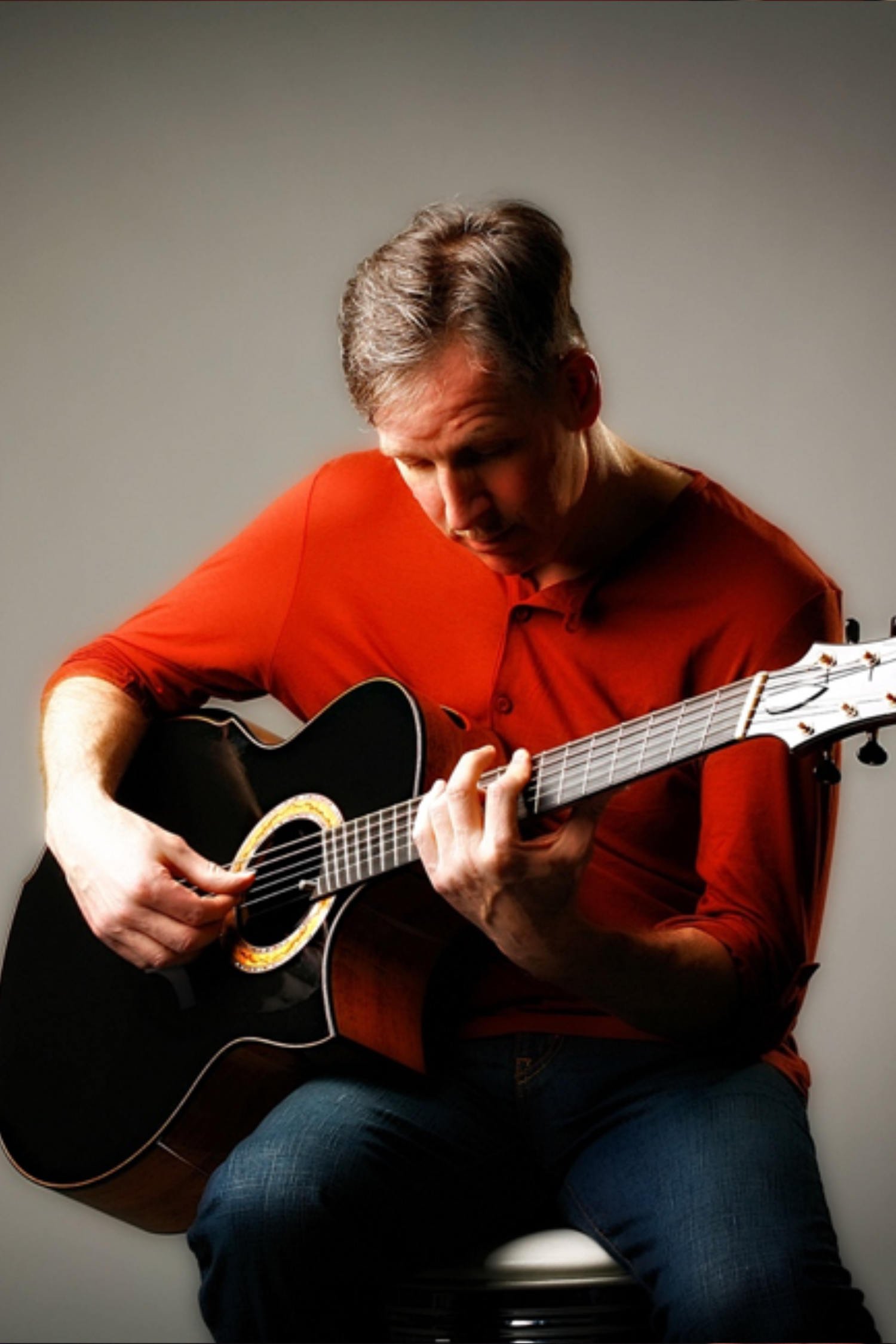 Mark Vickness. Portrait of a man with crossed arms, light gray background, wearing a dark long-sleeve shirt.
