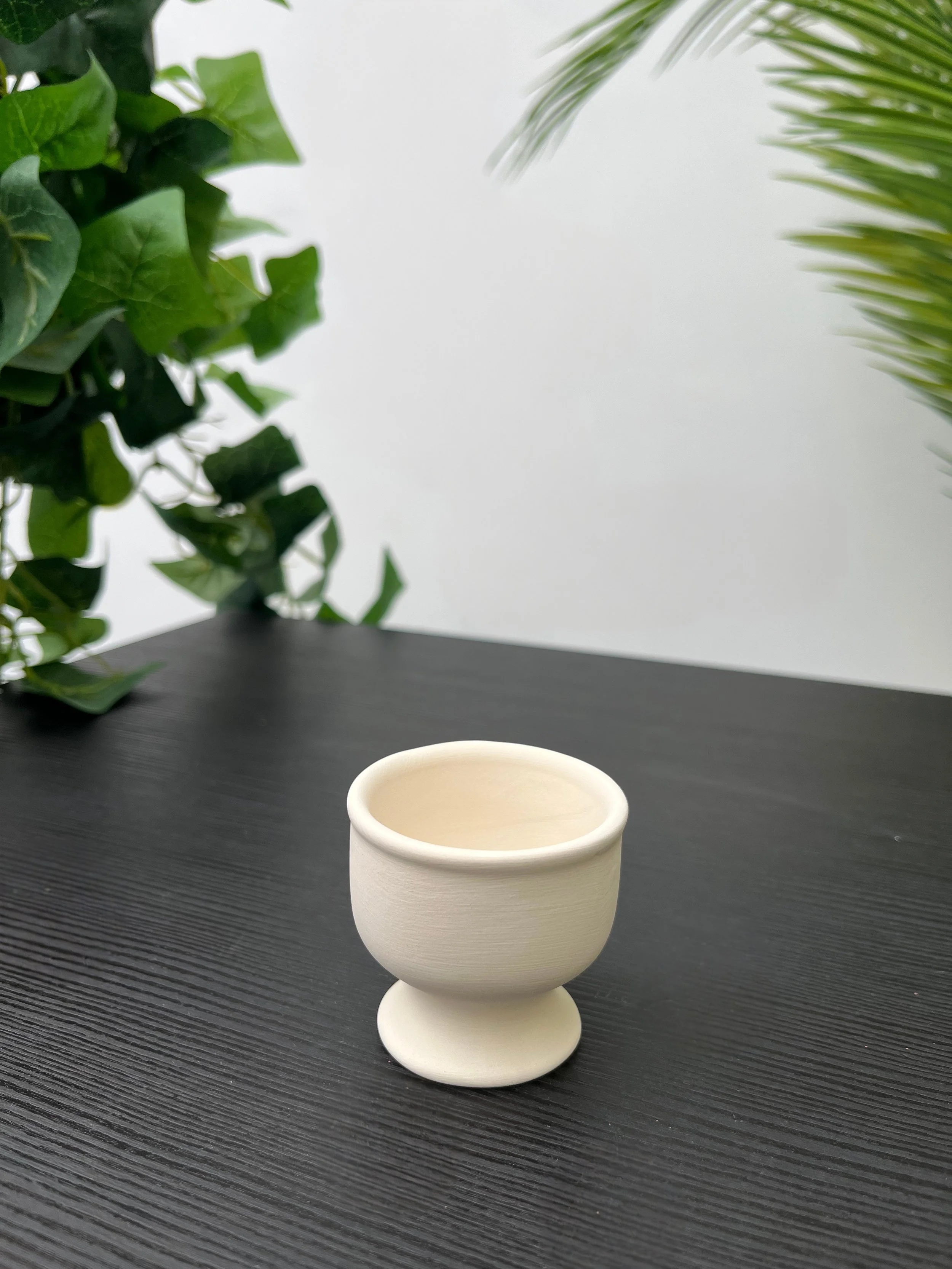 White decorative egg cup on a black table