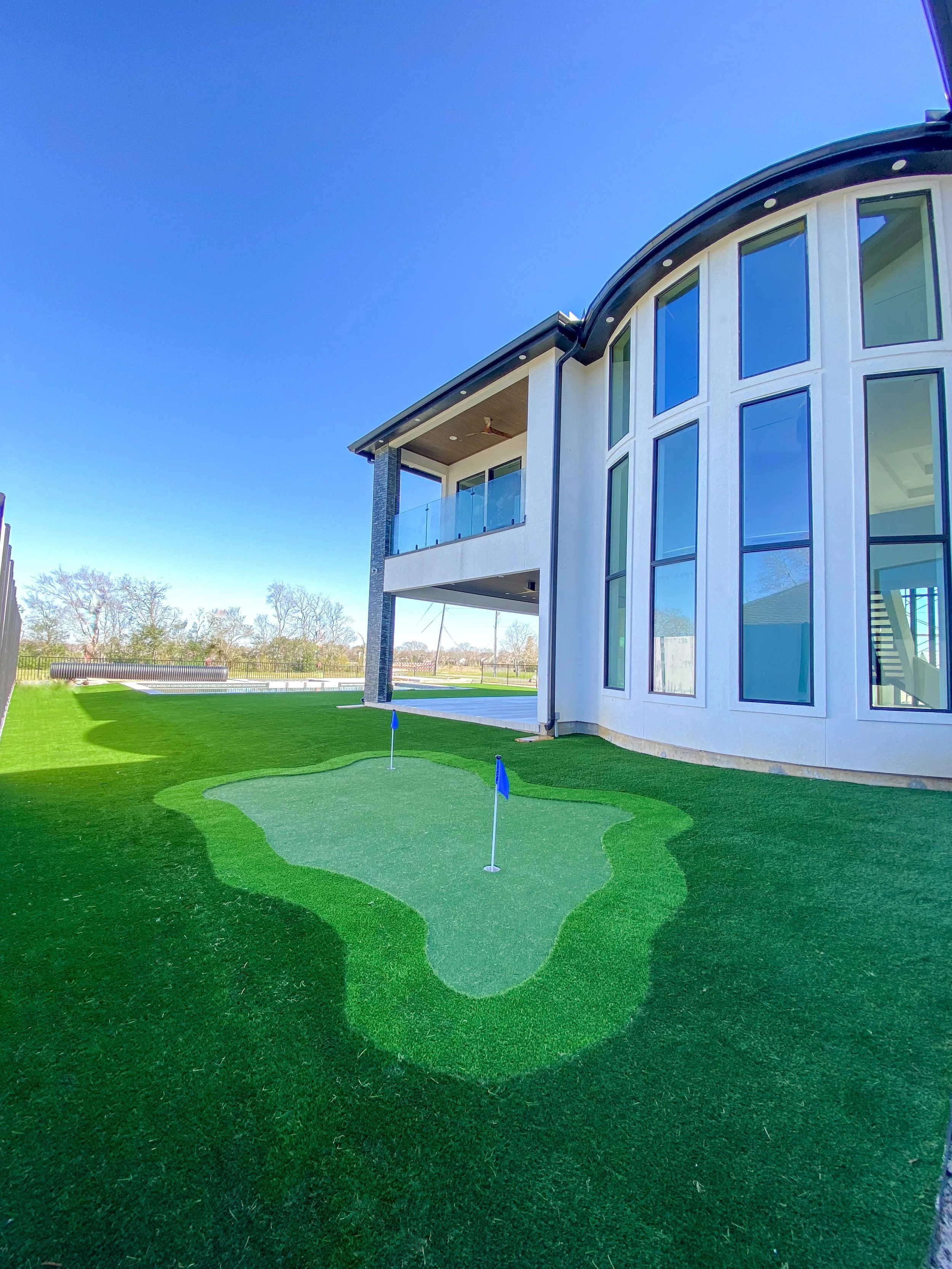 Artificial turf mini golf hole beside a house.