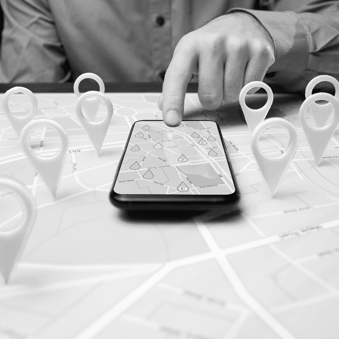 Person using a smartphone on a map with location pins.