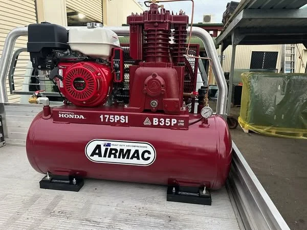 Red Airmac portable air compressor with Honda engine, 175 PSI, B35P model, mounted on a metal surface.