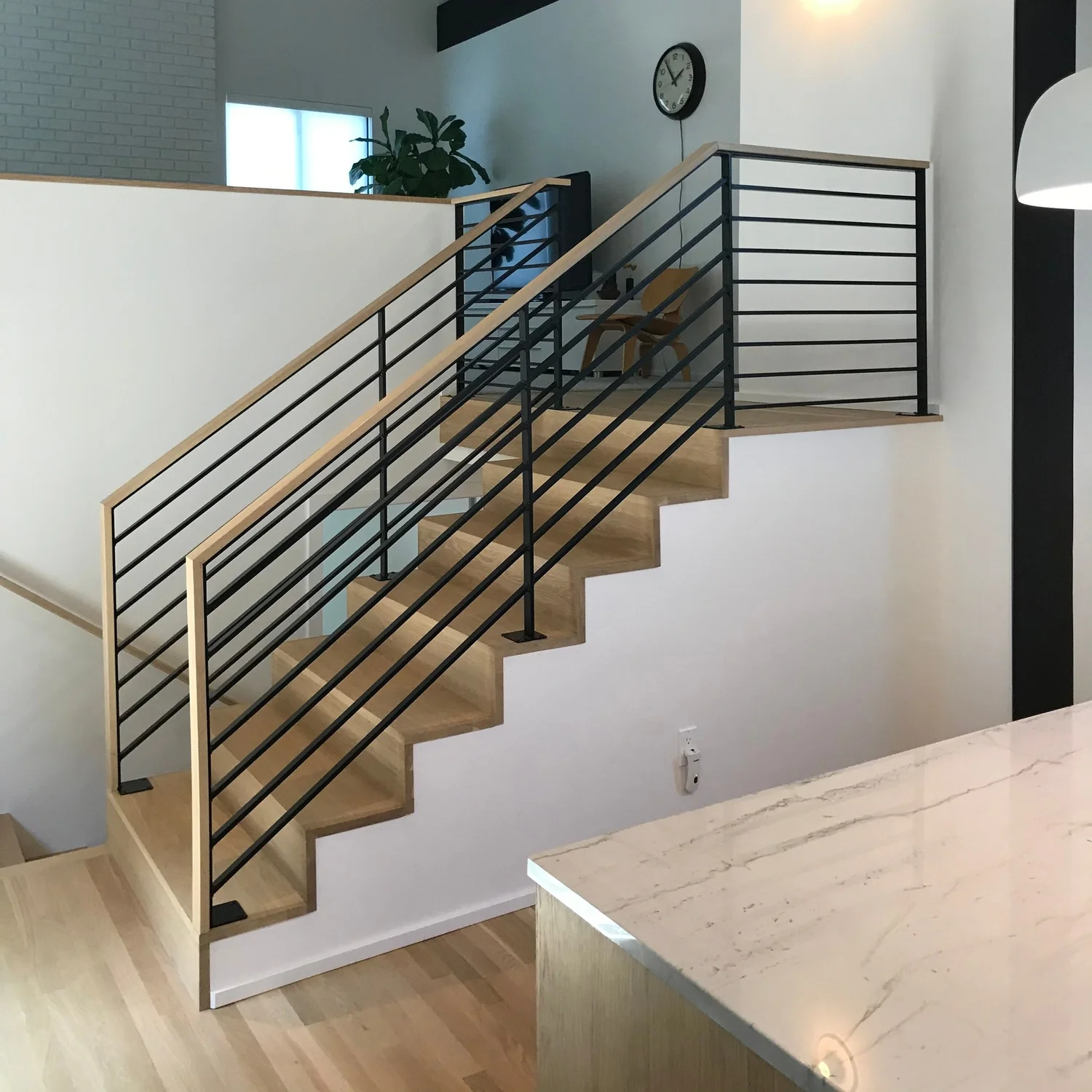 Wood staircase with black horizontal metal railing