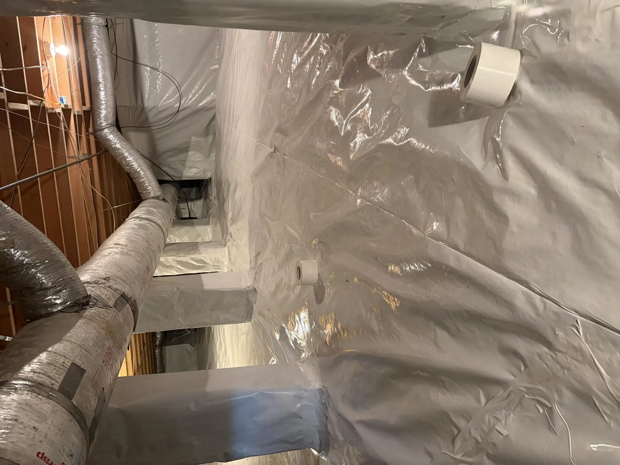 Encapsulated crawl space with insulated supply ducts above a sealed floor liner