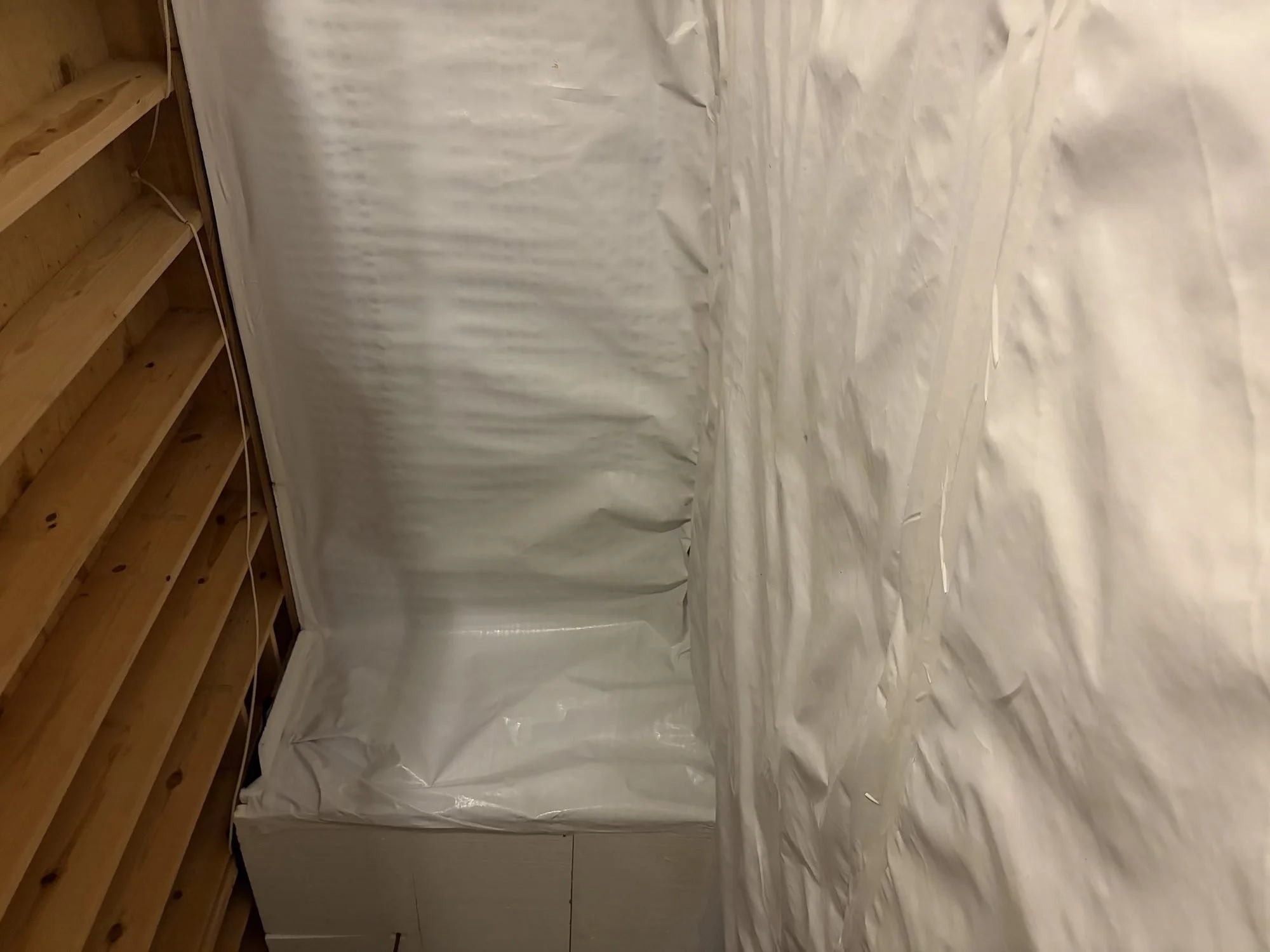 Support pier wrapped in vapor barrier beside a sealed crawl space wall, Tennessee