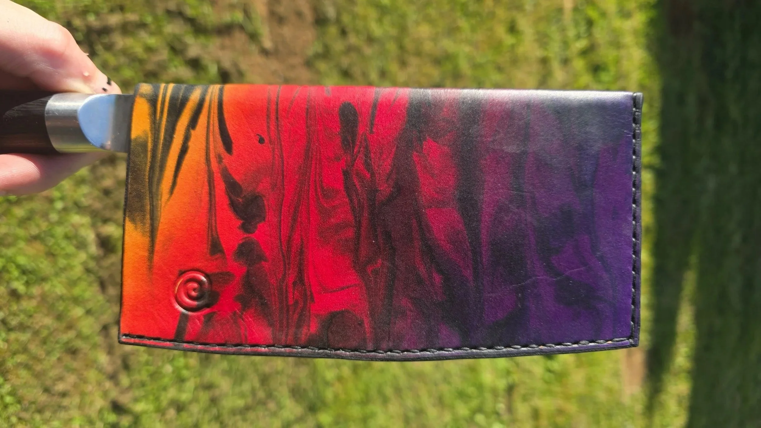 This is an example of what would be an XL sheath for an 8" vegetable cleaver, with a yellow, red, purple "sunset" fade, with black marble, and a spiral stamp.