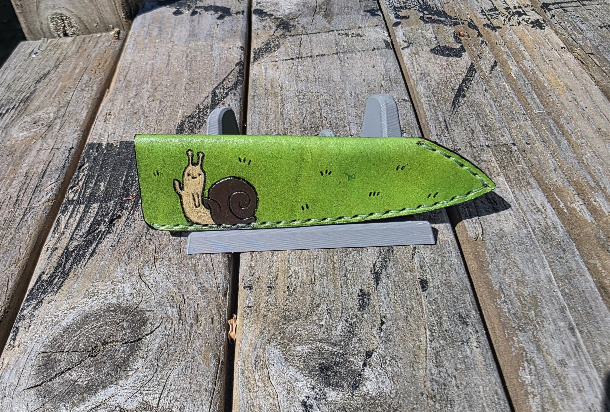 A mini custom sheath, with a custom "Adventure Time" inspired engraving, with green base.