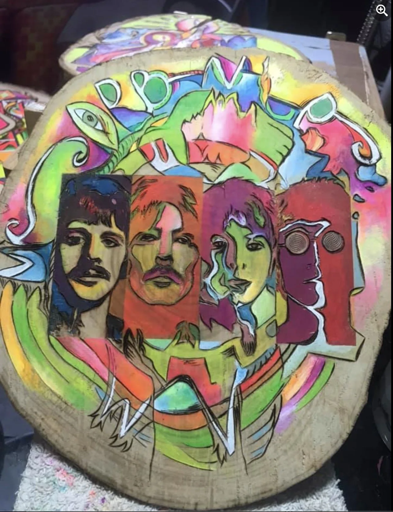 Colorful, abstract artwork painted on a wooden surface featuring portraits of four individuals with varying artistic styles and vibrant colors, including shades of green, pink, orange, and blue.